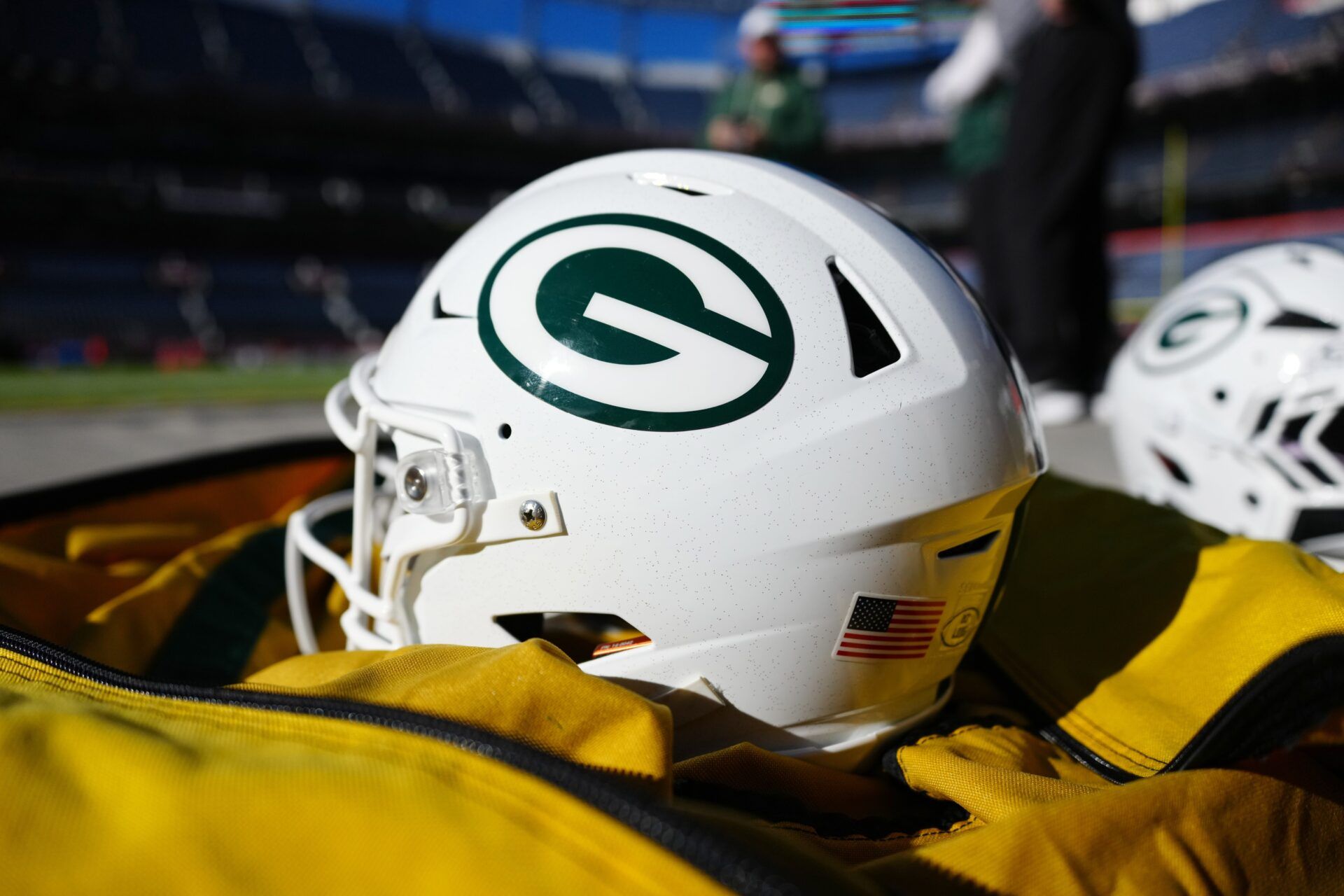 Green Bay Packers helmets sit on the sidelines prior to a game against the Denver Broncos at Empower Field at Mile High.