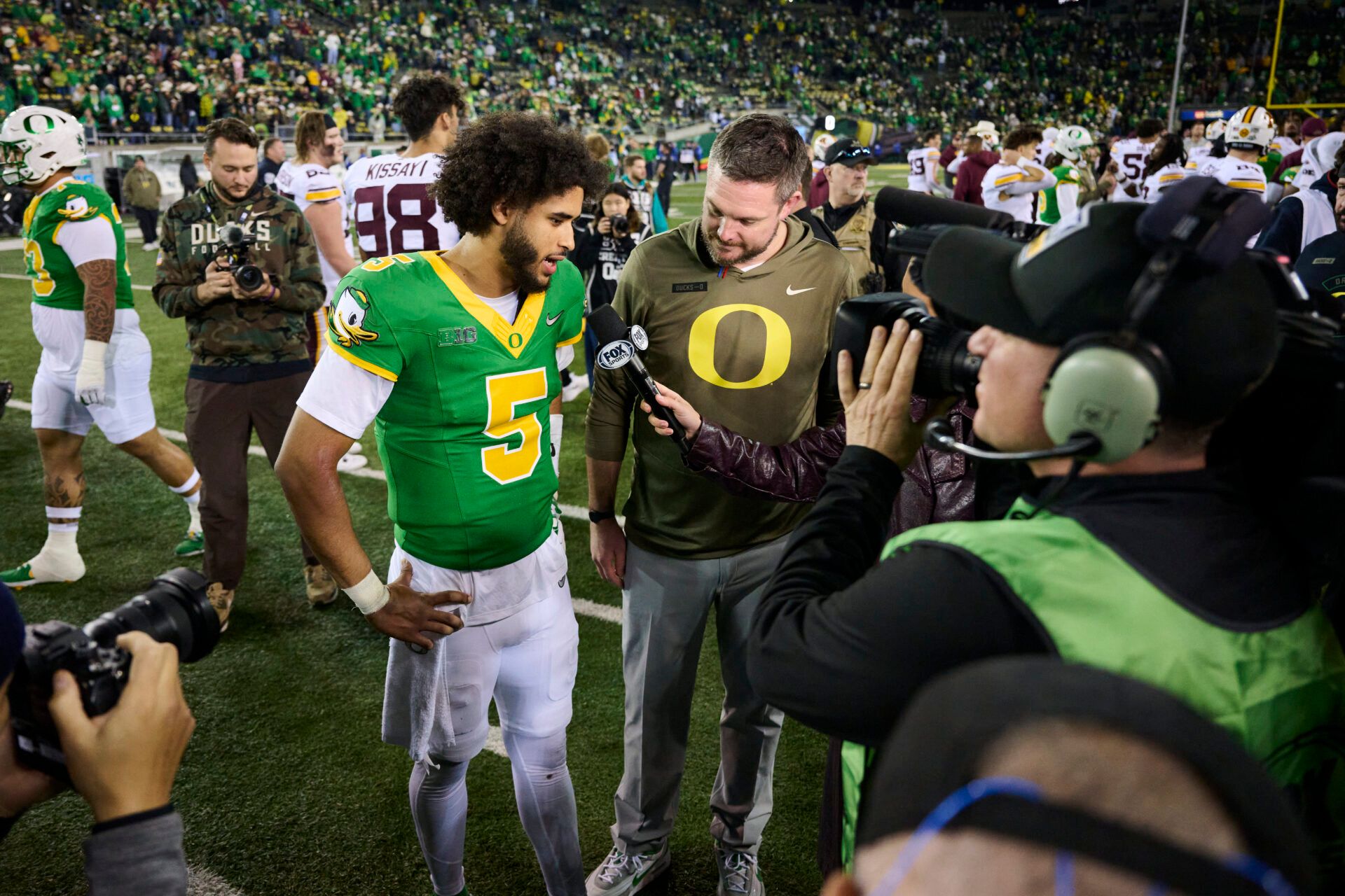 Oregon Ducks quarterback Dante Moore (5) and head coach Dan Lanning talk talk to a reporter after a game against the Minnesota Golden Gophers at Autzen Stadium.