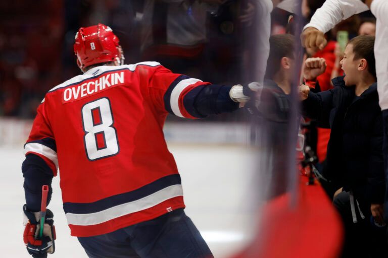 Washington Capitals left wing Alex Ovechkin (8) celebrates through he glass with his son Sergei (R) after scoring a goal against the Dallas Stars during the third period at Capital One Arena.