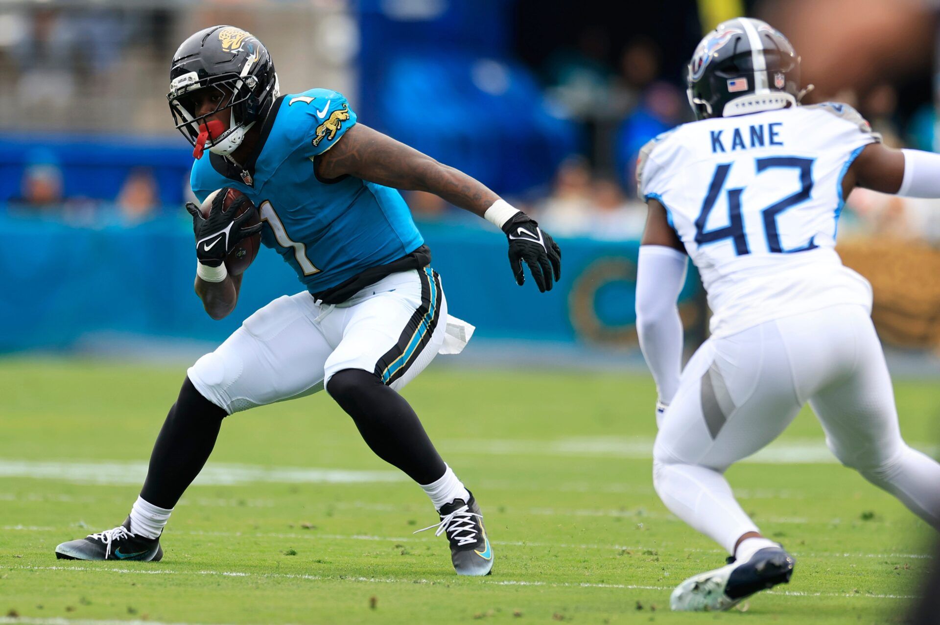 Jacksonville Jaguars running back Travis Etienne Jr. (1) jukes against Tennessee Titans safety Sanoussi Kane (42) during the first quarter of an NFL football matchup at EverBank Stadium, Sunday, Jan. 4, 2026, in Jacksonville, Fla. The Jaguars defeated the Titans 41-7, capturing the AFC South title. [Corey Perrine/Florida Times-Union]