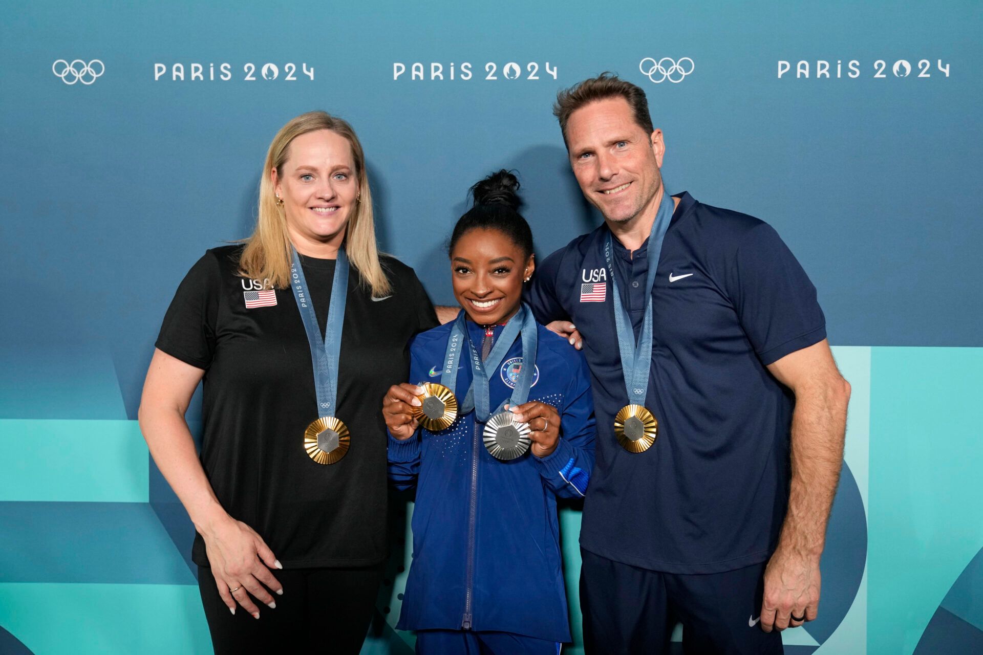 Simone Biles of the United States poses for a photo with coaches Cecile Landi and Laurent Landi after day three of the gymnastics event finals during the Paris 2024 Olympic Summer Games.