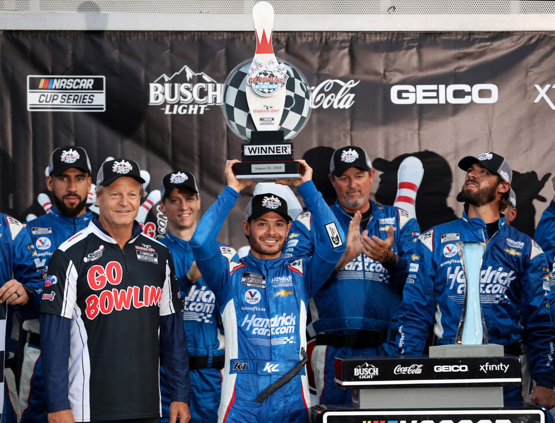 NASCAR Cup Series driver Kyle Larson raises the winner's trophy in victory lane after winning the Go Bowling at The Glen at Watkins Glen International.