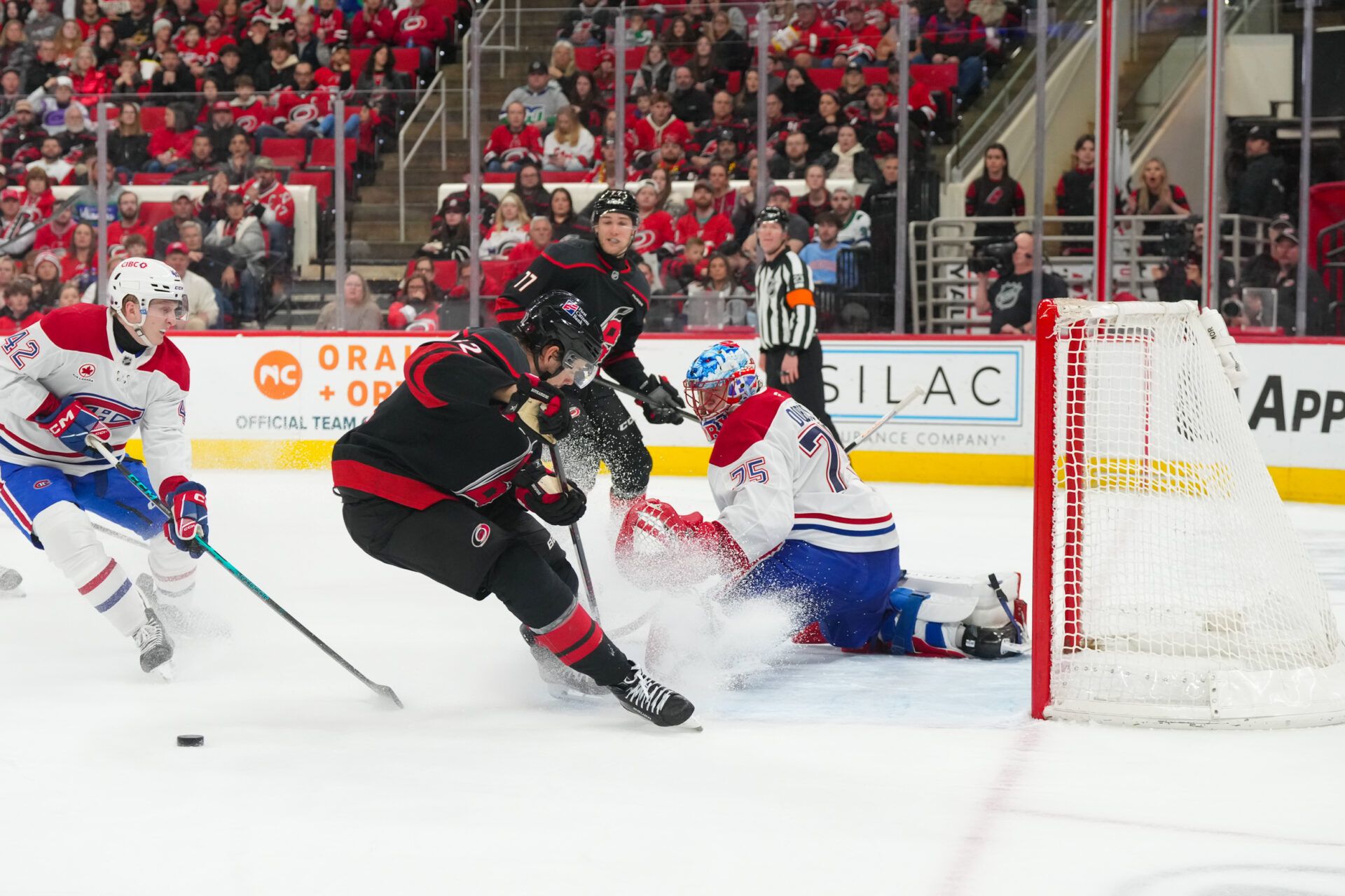 Montral Canadiens goaltender Jakub Dobes (75) kicks the shot past Carolina Hurricanes center Jesperi Kotkaniemi (82) during the third period at Lenovo Center.