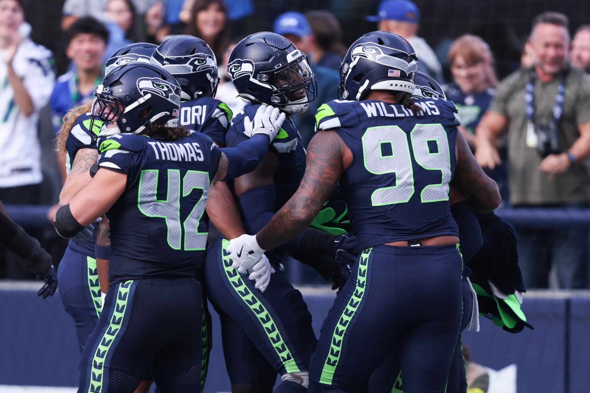 Seattle Seahawks defensive end DeMarcus Lawrence (0) celebrates with Seattle Seahawks defensive end Leonard Williams (99) and Seattle Seahawks linebacker Drake Thomas (42) after recovering a fumble to score a touchdown during the second quarter against the Arizona Cardinals at Lumen Field.
