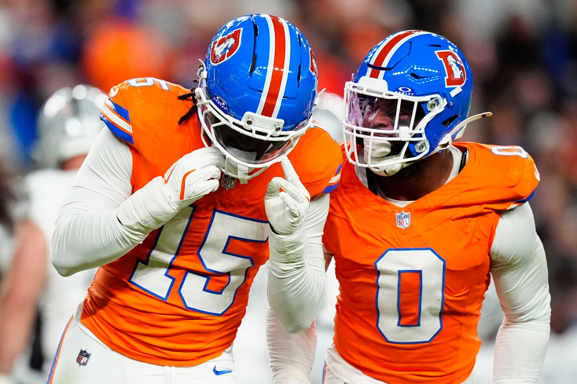 Denver Broncos linebacker Nik Bonitto (15) and linebacker Jonathon Cooper (0) react during the first half at Empower Field at Mile High.