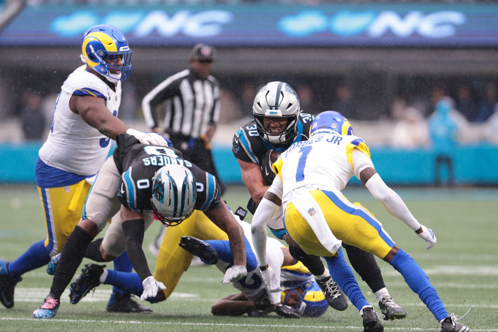 Carolina Panthers running back Chuba Hubbard (30) rushes as Los Angeles Rams cornerback Emmanuel Forbes Jr. (1) defends during the fourth quarter at Bank of America Stadium.