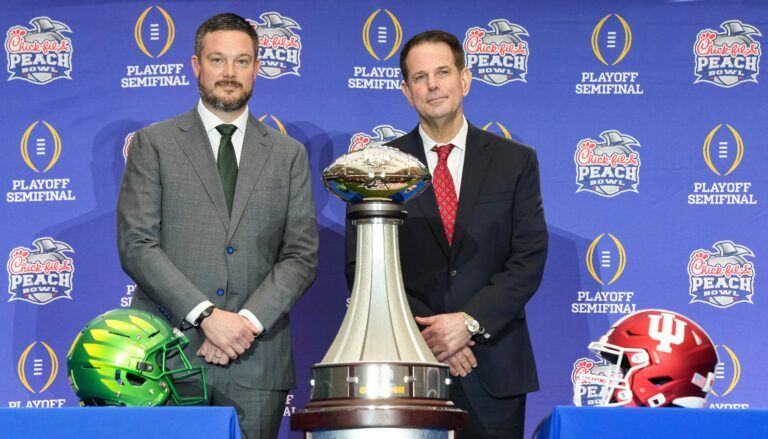 Oregon Ducks head coach Dan Lanning and Indiana Hoosiers head coach Curt Cignetti smile for a photo Thursday, Jan. 8, 2026, during a coaches' press conference ahead of the College Football Playoff Peach Bowl game at the College Football Hall of Fame in Atlanta.