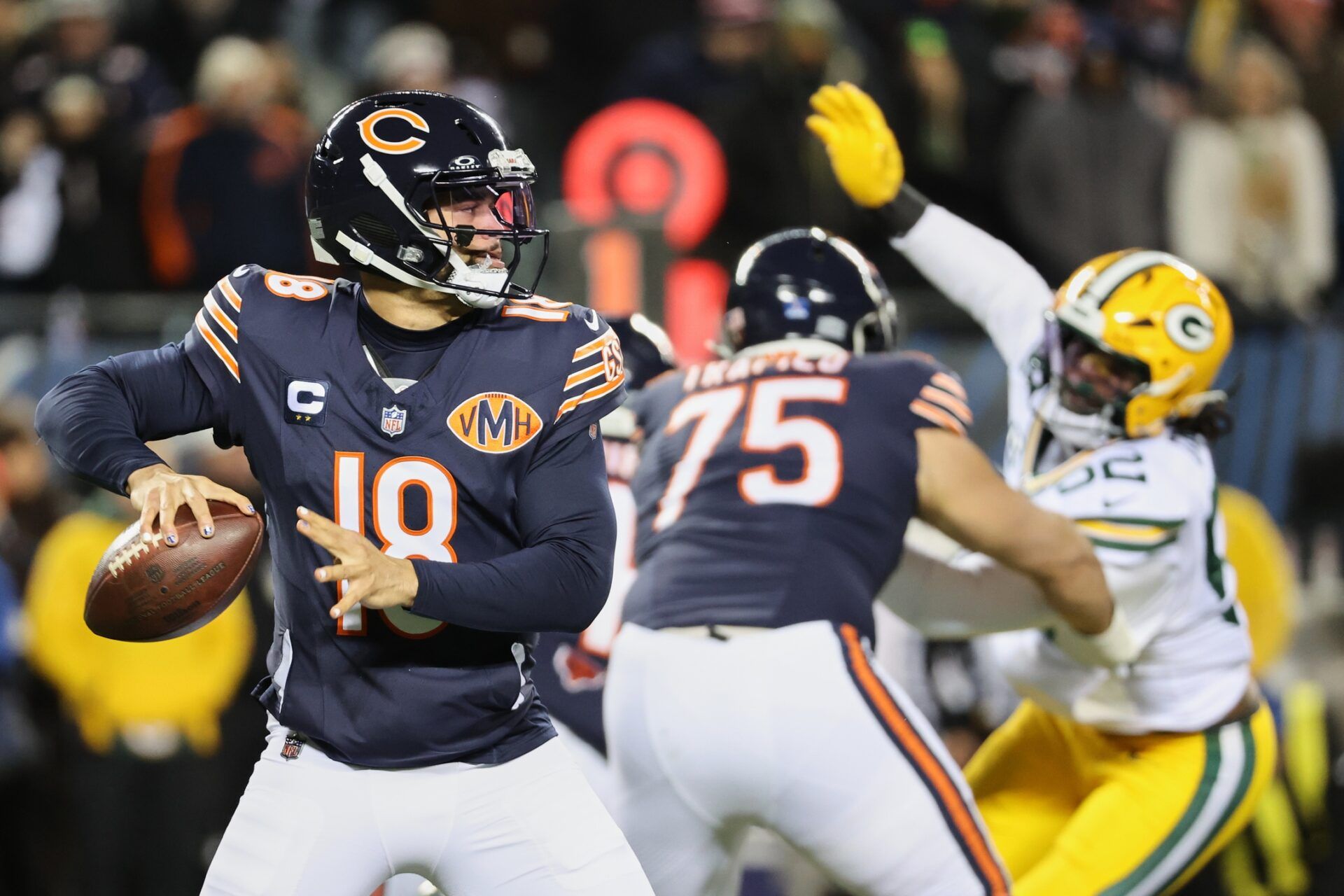 Chicago Bears quarterback Caleb Williams (18) prepares to throw a pass and offensive tackle Ozzy Trapilo (75) blocks against Green Bay Packers defensive end Rashan Gary (52) during the first quarter at Soldier Field.