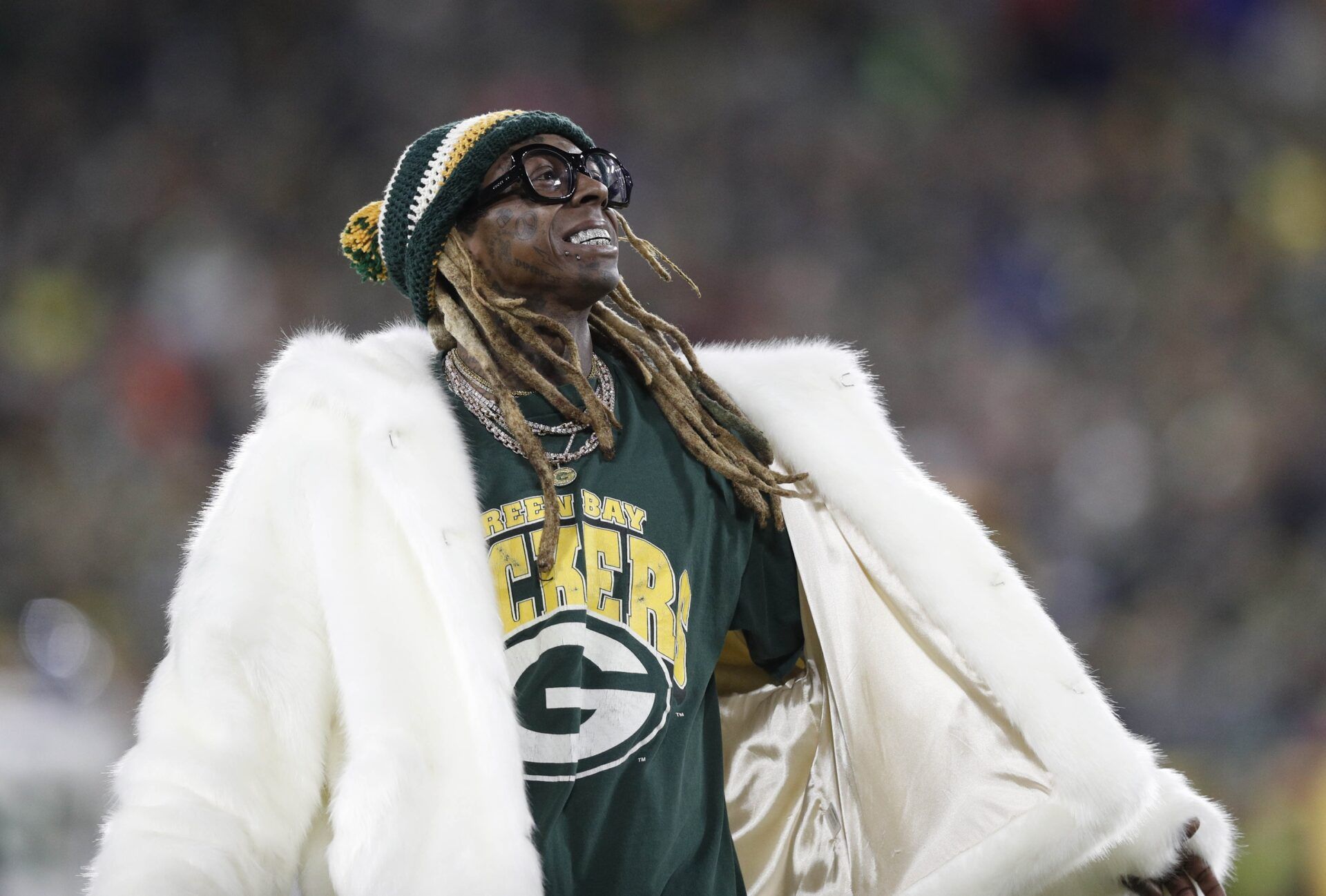 Recording artist Lil Wayne addresses the crowd in the second half of a NFC Divisional Round playoff football game between the Green Bay Packers and Seattle Seahawks at Lambeau Field.
