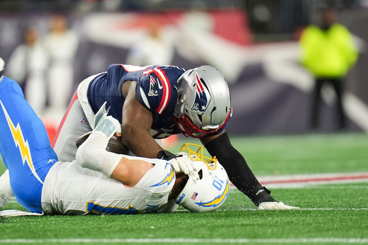 New England Patriots defensive end Milton Williams (97) sacks Los Angeles Chargers quarterback Justin Herbert (10) during the fourth quarter in an AFC Wild Card Round game at Gillette Stadium.