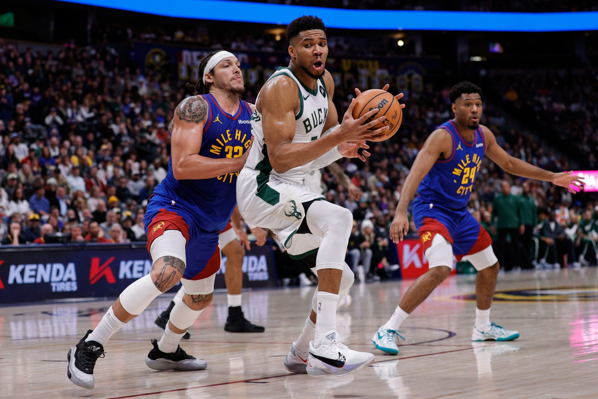 Milwaukee Bucks forward Giannis Antetokounmpo (34) controls the ball under pressure from Denver Nuggets forward Aaron Gordon (32) in the fourth quarter at Ball Arena.