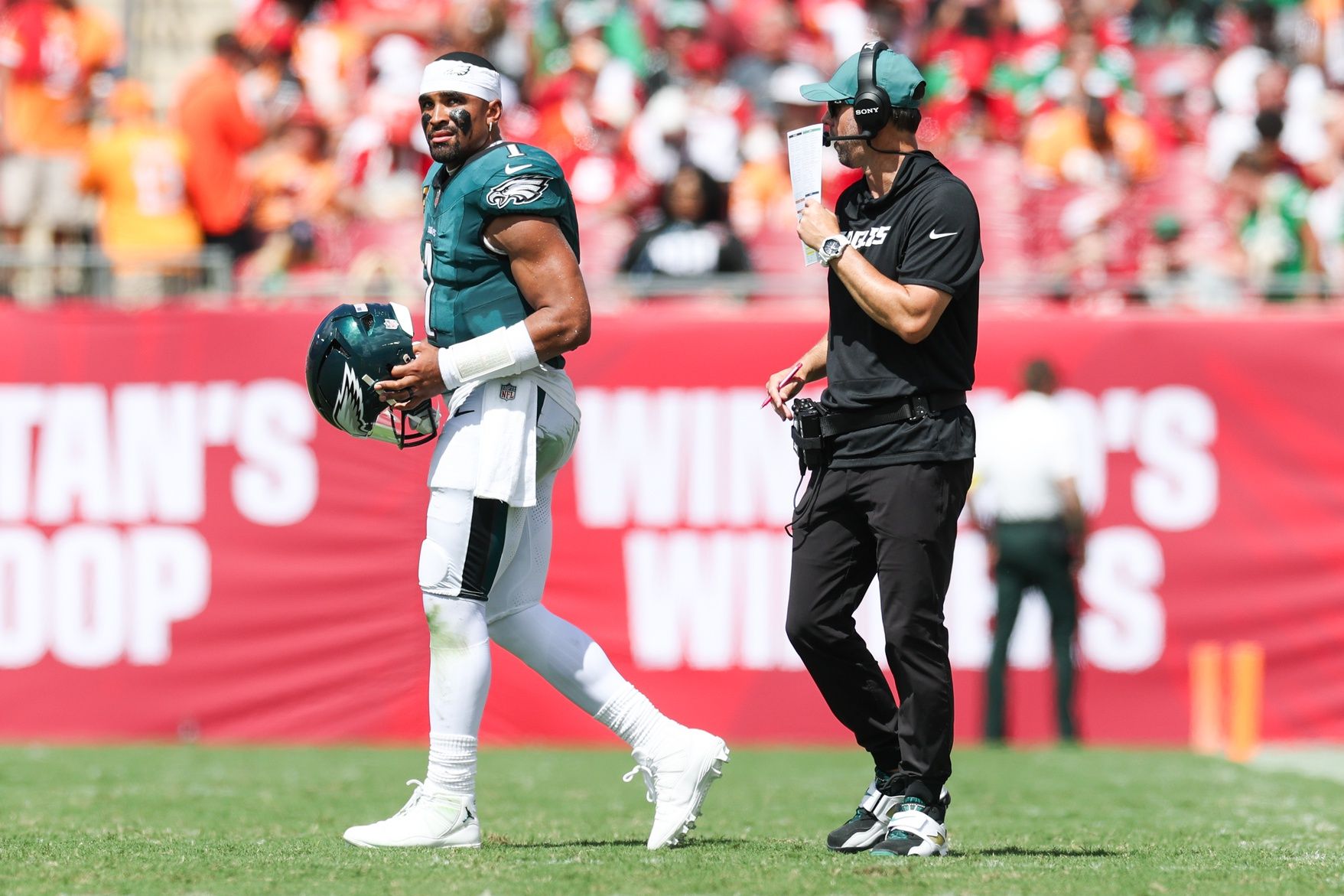 Philadelphia Eagles offensive coach Kevin Patullo communicates with quarterback Jalen Hurts (1) during a timeout in the second quarter against the Tampa Bay Buccaneers at Raymond James Stadium.
