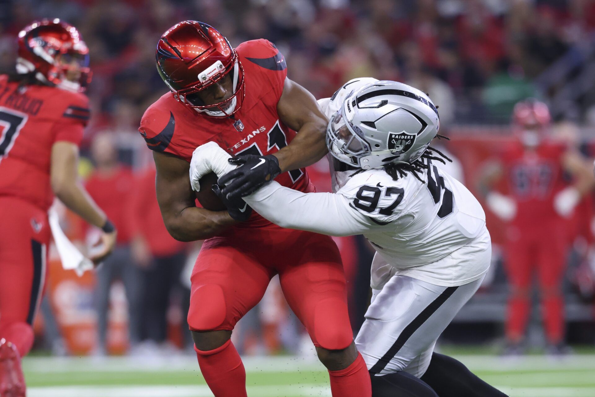 Houston Texans running back Nick Chubb (21) runs with the ball as Las Vegas Raiders defensive tackle Tonka Hemingway (97) makes a tackle during the fourth quarter at NRG Stadium.