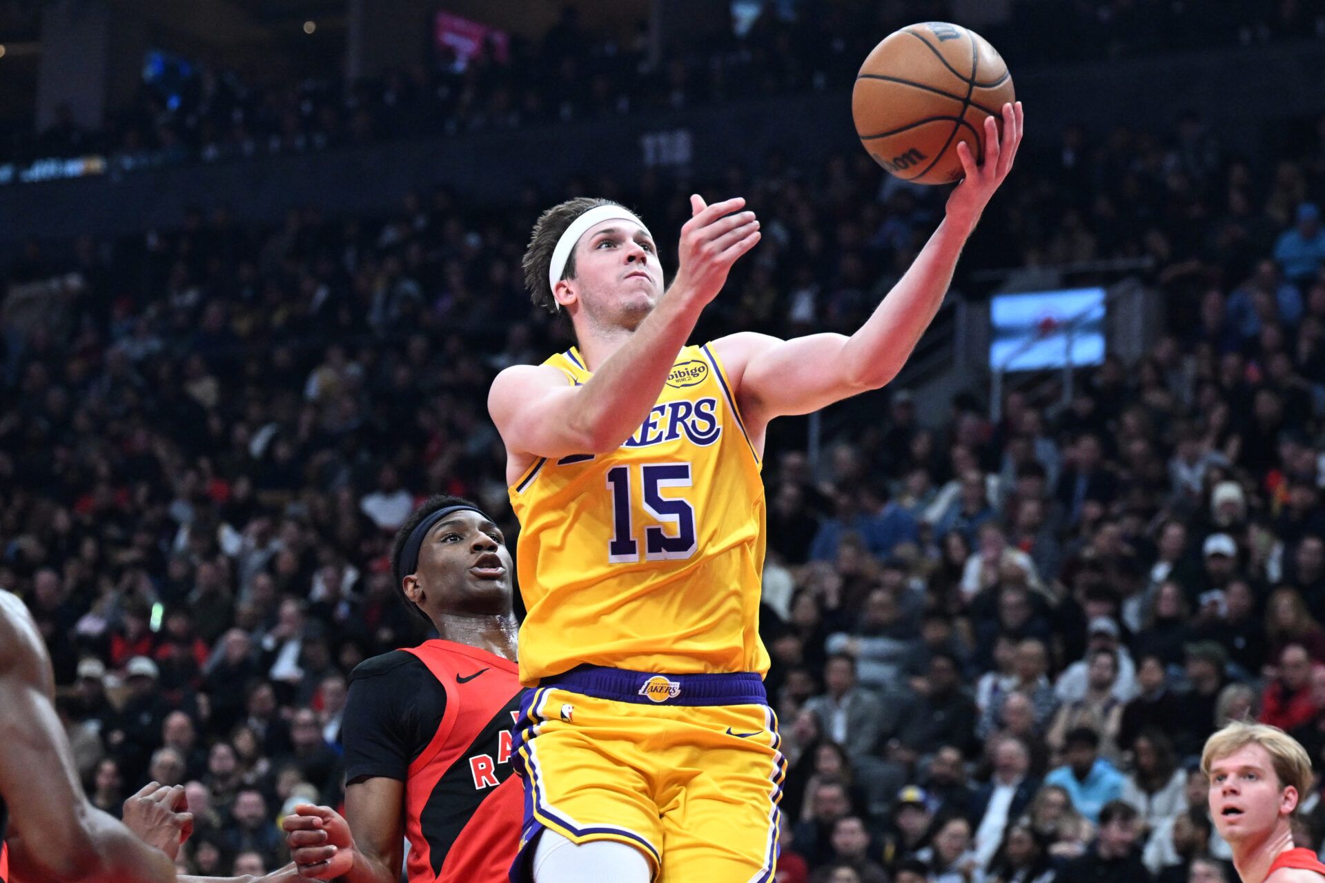 Los Angeles Lakers guard Austin Reaves (15) drives to the basket past Toronto Raptors guard Ja'Kobe Walter (14) in the first half at Scotiabank Arena.