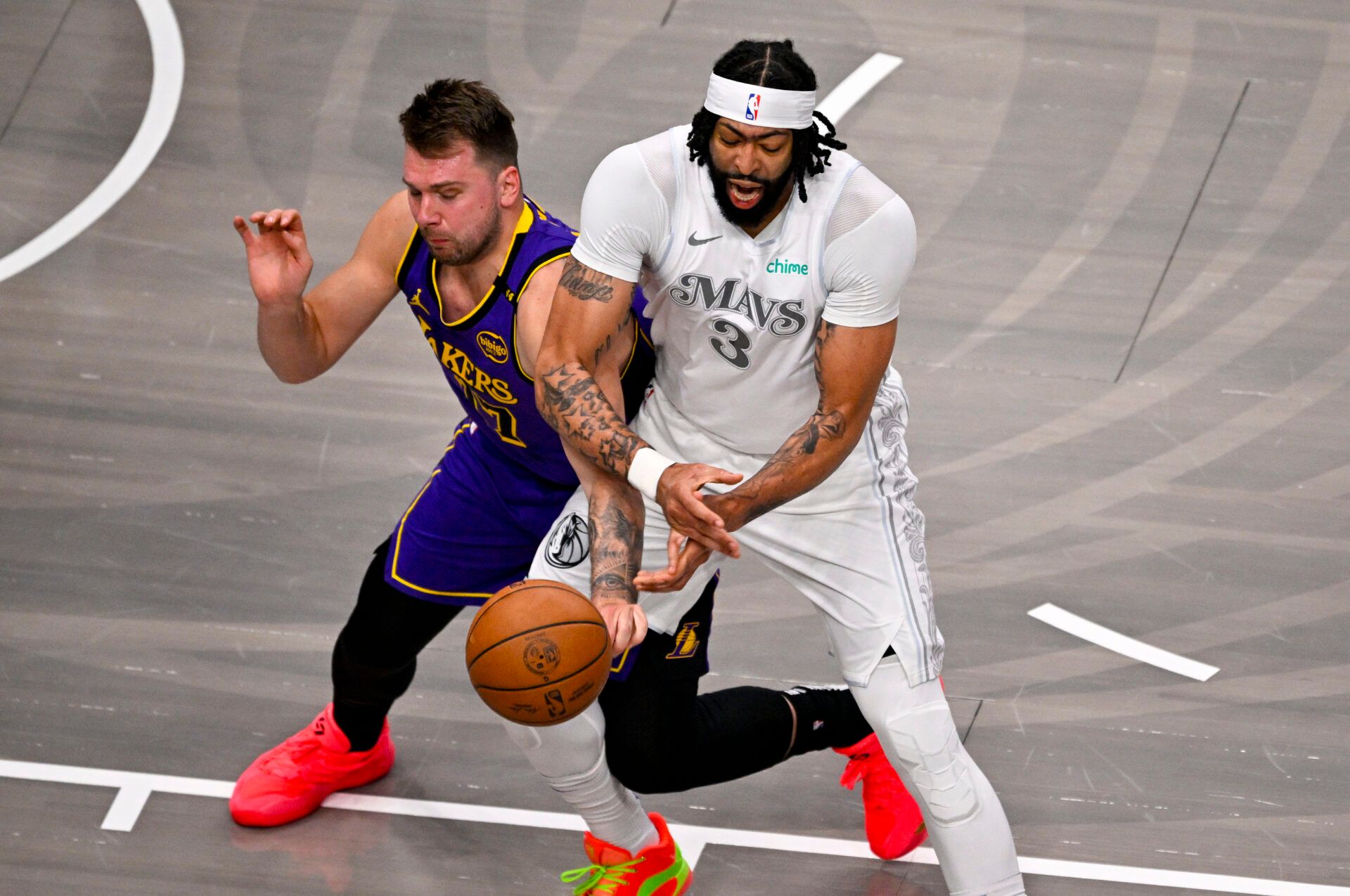 Los Angeles Lakers guard Luka Doncic (77) knocks the ball away from Dallas Mavericks forward Anthony Davis (3) during the first quarter at the American Airlines Center.