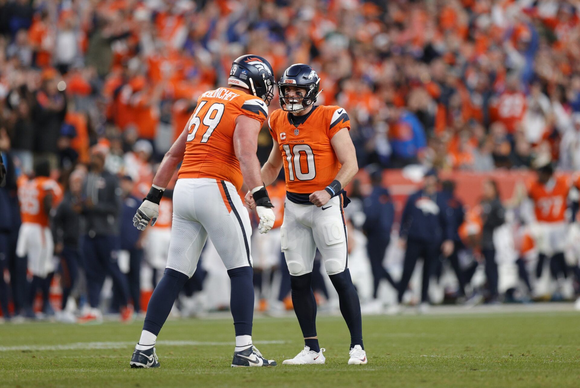 Denver Broncos quarterback Bo Nix (10) celebrates a touchdown with offensive tackle Mike McGlinchey (69) during the third quarter against the Green Bay Packers at Empower Field at Mile High.