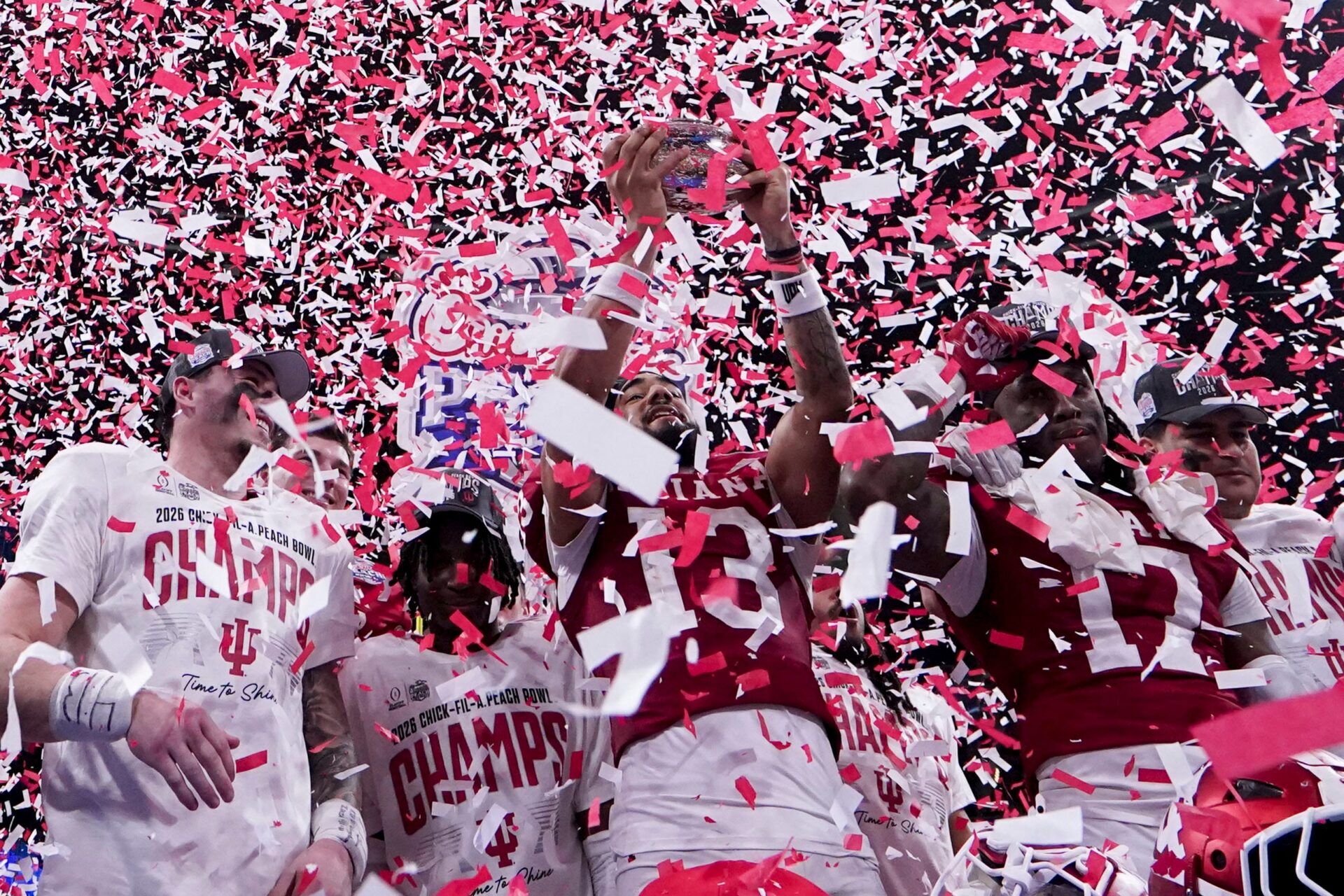 Indiana Hoosiers wide receiver Elijah Sarratt (13) hoists the trophy while celebrating with his teammates as confetti falls Friday, Jan. 9, 2026, after defeating the Oregon Ducks in the Peach Bowl and semifinal game of the College Football Playoff at Mercedes-Benz Stadium in Atlanta.
