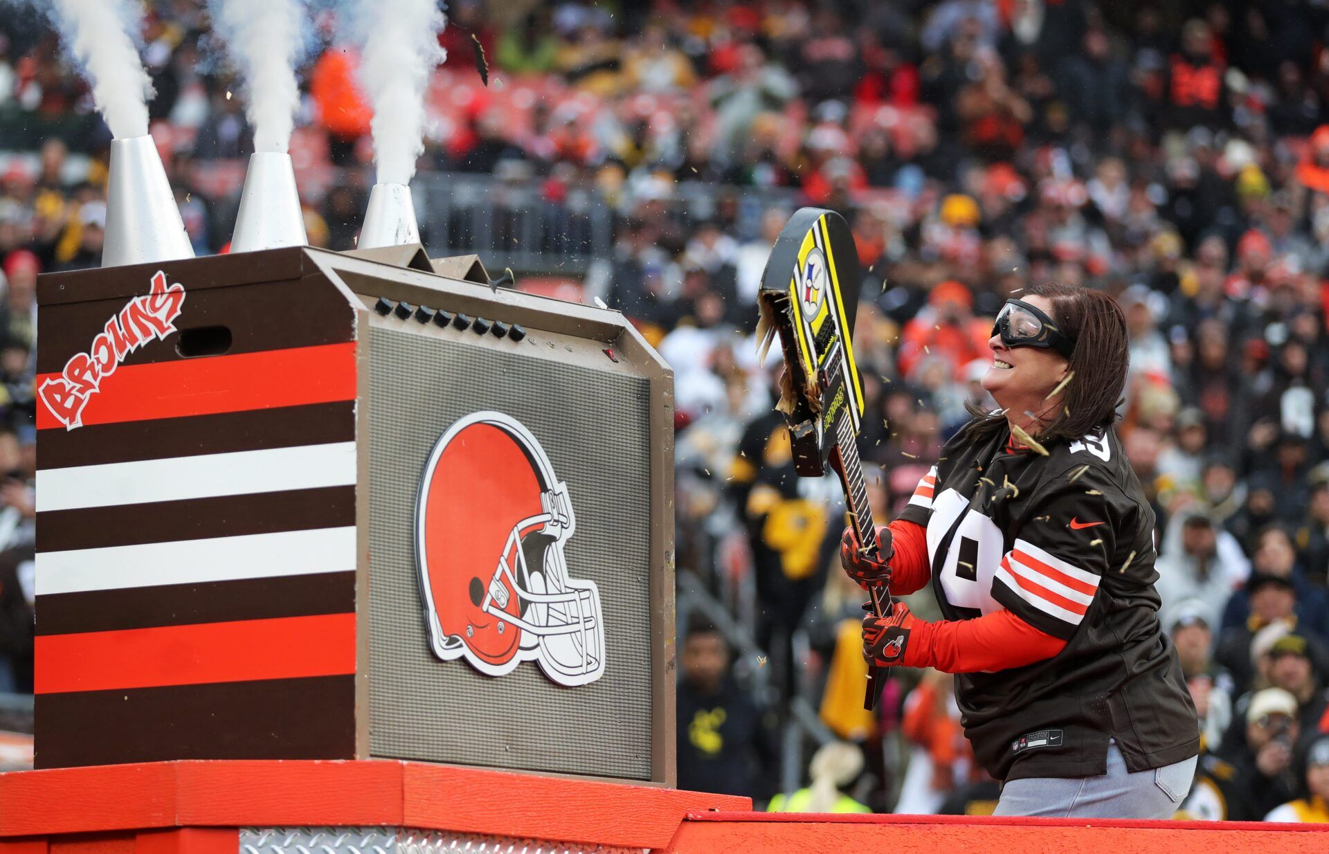 Kimberly Dunlap Kane, mother of Bryce Dunlap, the Browns fan who donated his liver to former Browns quarterback Bernie Kosar, smashes the guitar before an NFL football game at Huntington Bank Field, Dec. 28, 2025, in Cleveland, Ohio.