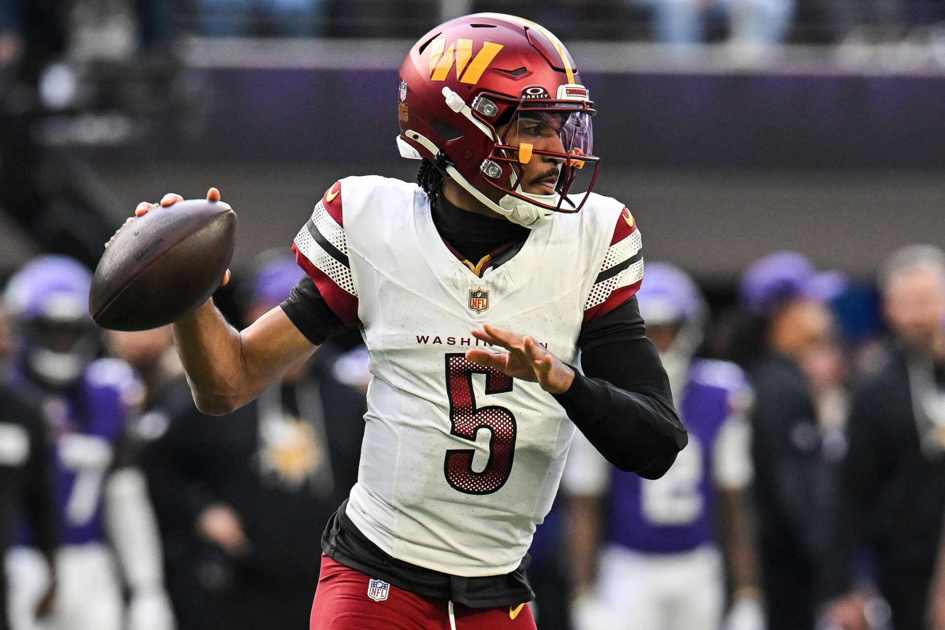 Washington Commanders quarterback Jayden Daniels (5) drops back to pass against the Minnesota Vikings during the first half at U.S. Bank Stadium.