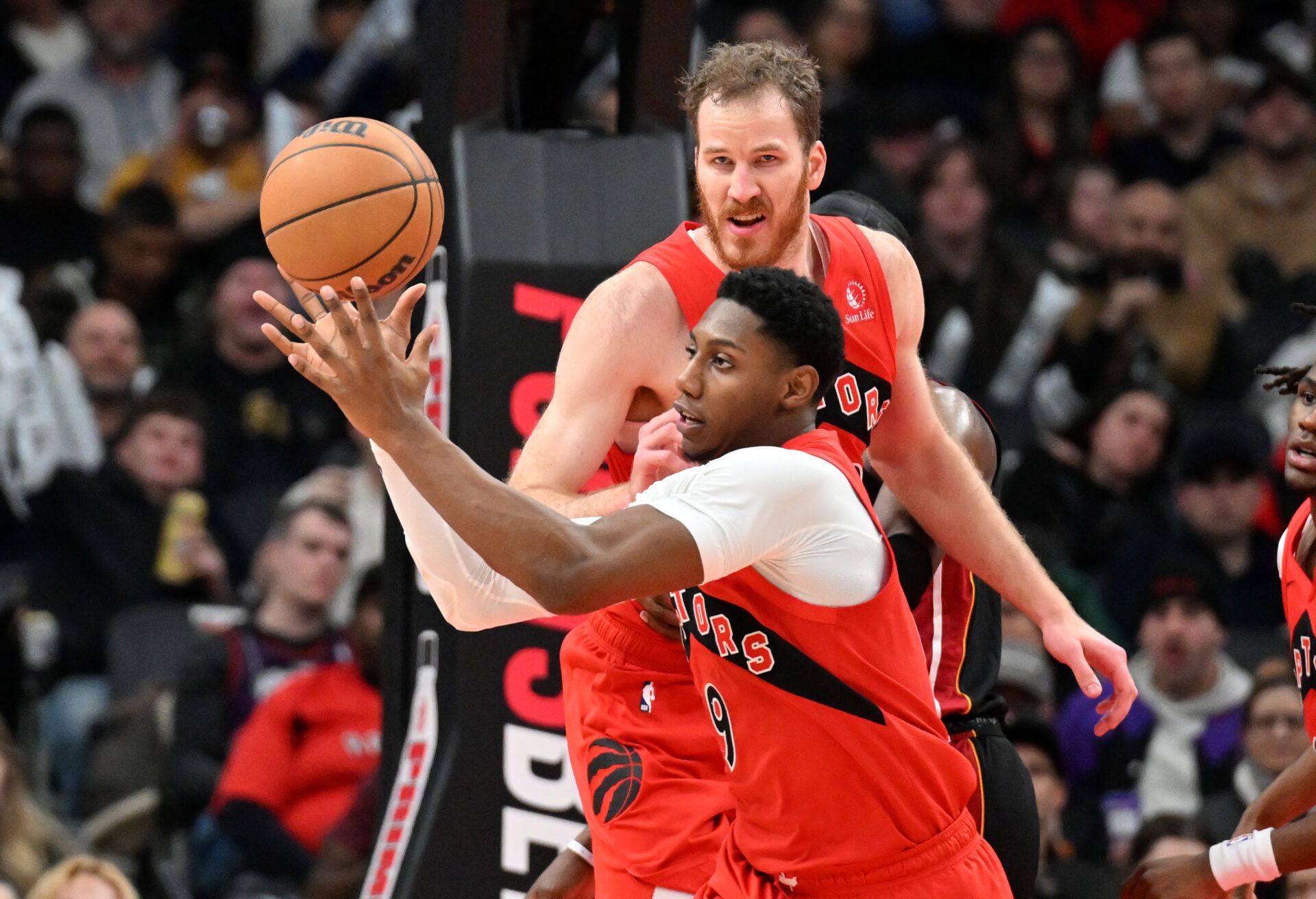 Toronto Raptors forward RJ Barrett (9) gathers in a rebound as centre Jakob Poeltl (19) looks on in the first half against the Miami Heat at Scotiabank Arena.