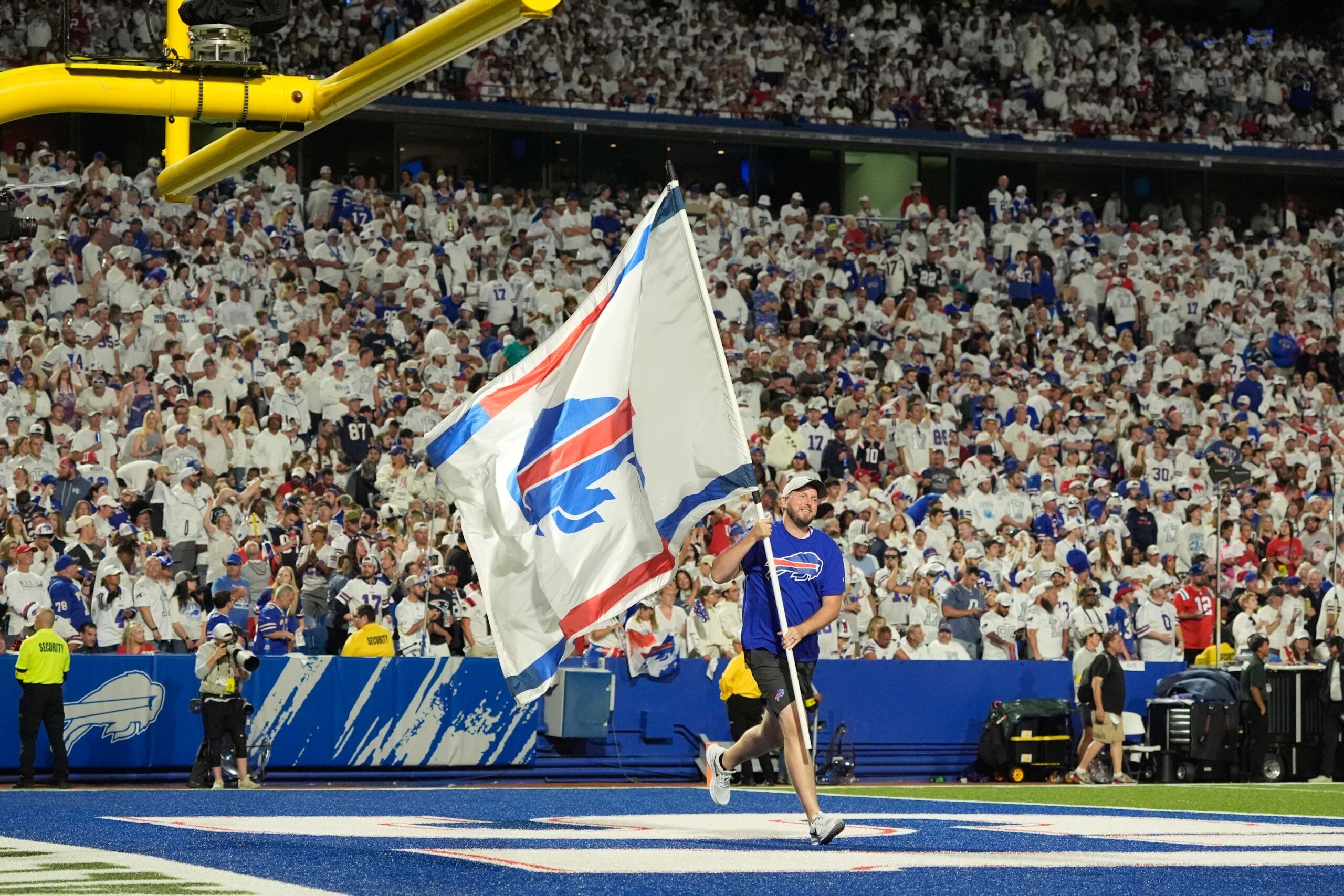 A Buffalo Bills Cheerleader waves a Bills flag to celebrate a score against the New England Patriots during the first half at Highmark Stadium.
