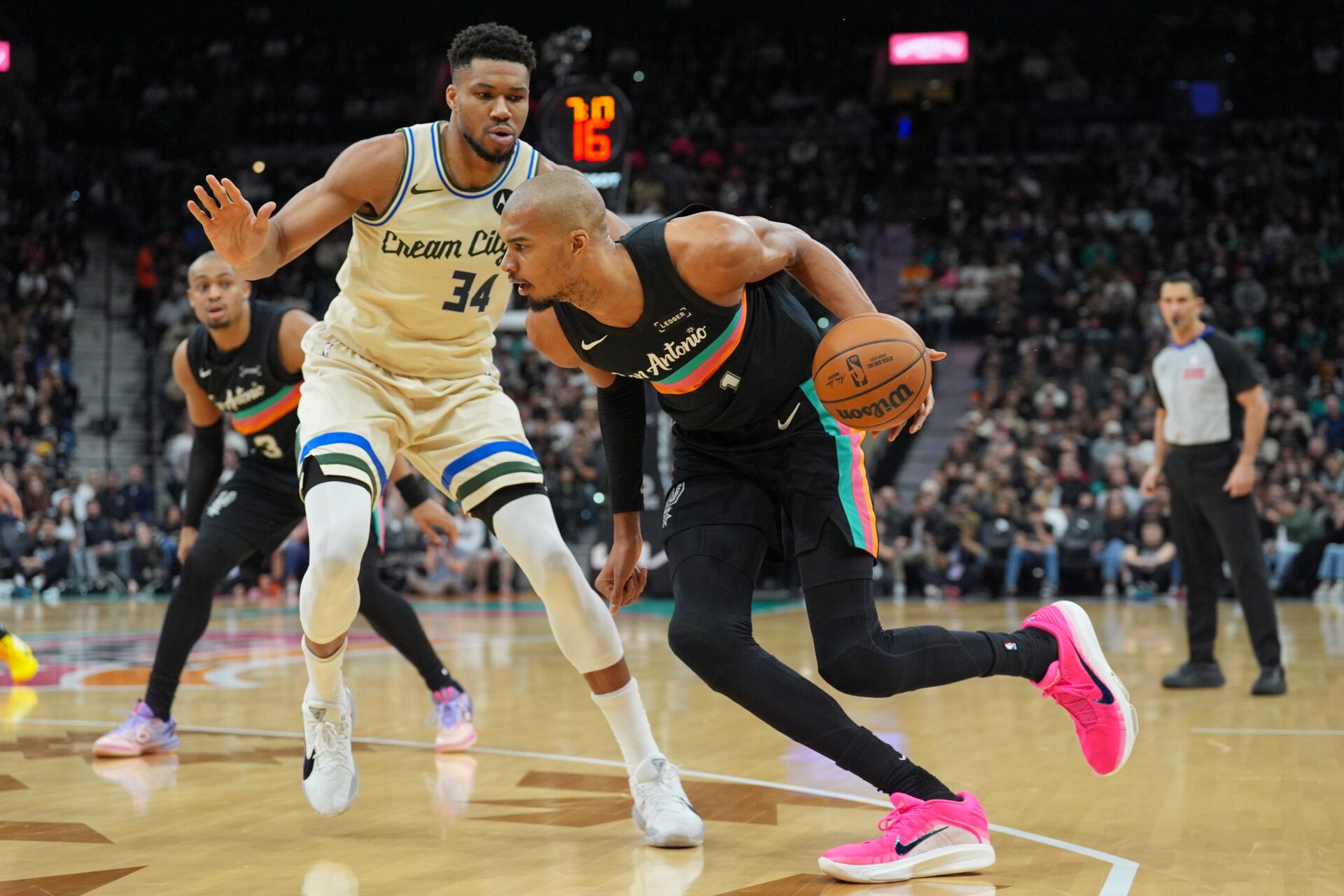 San Antonio Spurs forward/center Victor Wembanyama (1) dribbles against Milwaukee Bucks forward Giannis Antetokounmpo (34) in the first half at Frost Bank Center.