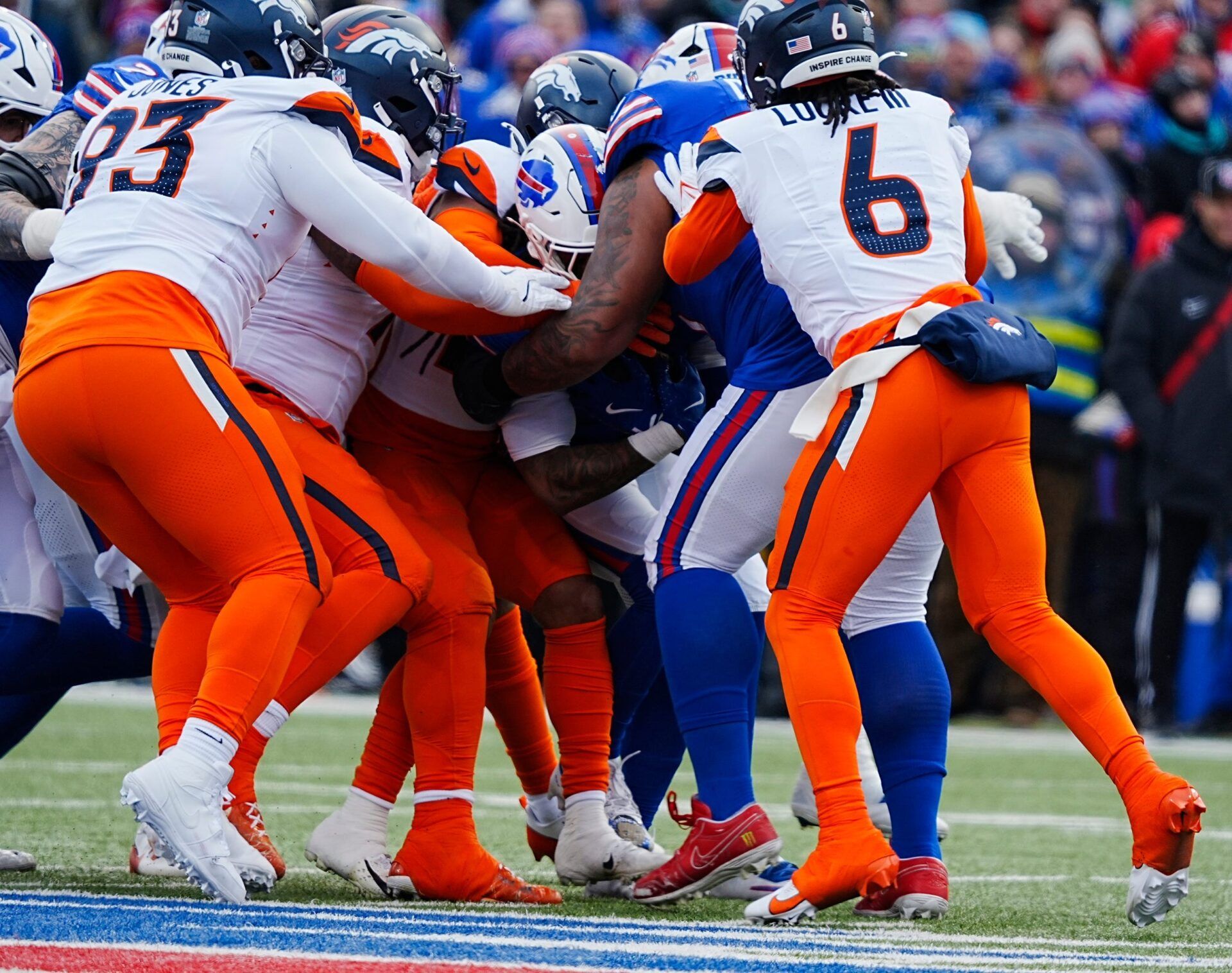 Buffalo Bills running back James Cook tries to make forward motion with teammate Buffalo Bills offensive tackle Dion Dawkins helping him by pulling him while a host of Denver Broncos try to bring him down during the first half of the Buffalo Bills wild card game against the Denver Broncos at Highmark Stadium in Orchard Park on Jan. 12, 2025. Syndication: USA TODAY