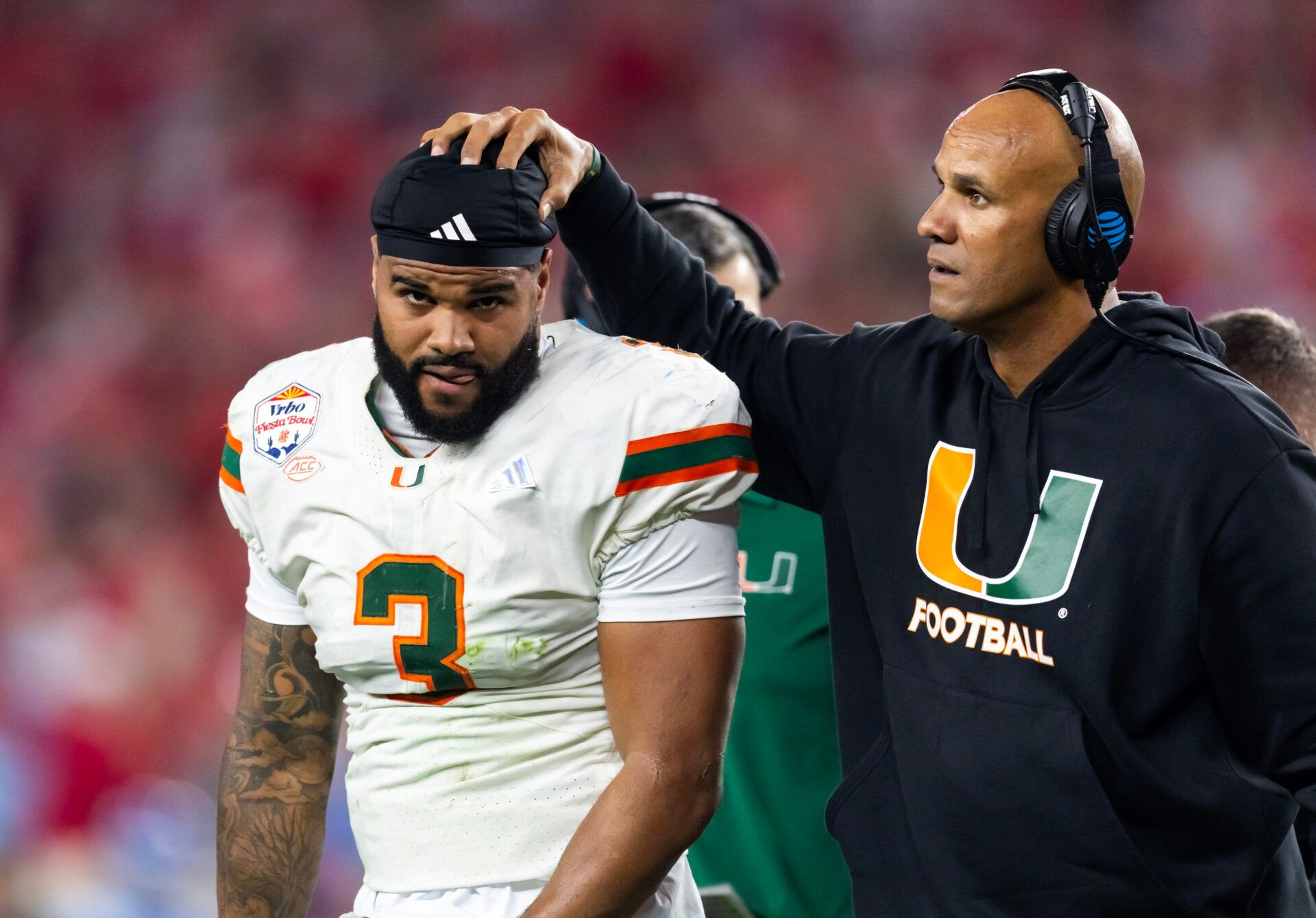 Miami Hurricanes defensive line coach Jason Taylor with defensive lineman Akheem Mesidor (3) against the Mississippi Rebels during the 2026 Fiesta Bowl and semifinal game of the College Football Playoff at State Farm Stadium.