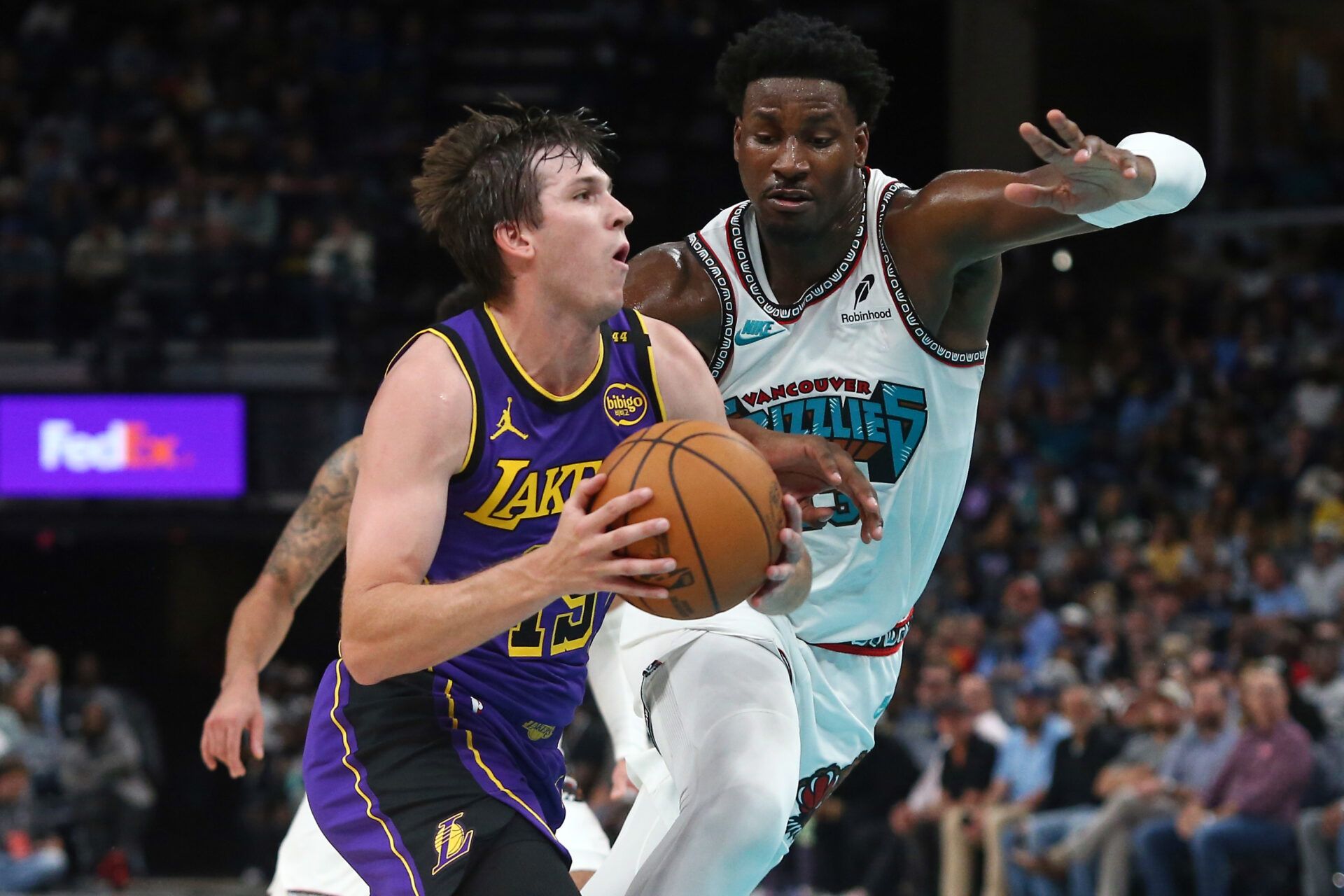 Los Angeles Lakers guard Austin Reaves (15) drives to the basket as Memphis Grizzlies forward Jaren Jackson Jr. (13) defends during the first half at FedExForum.