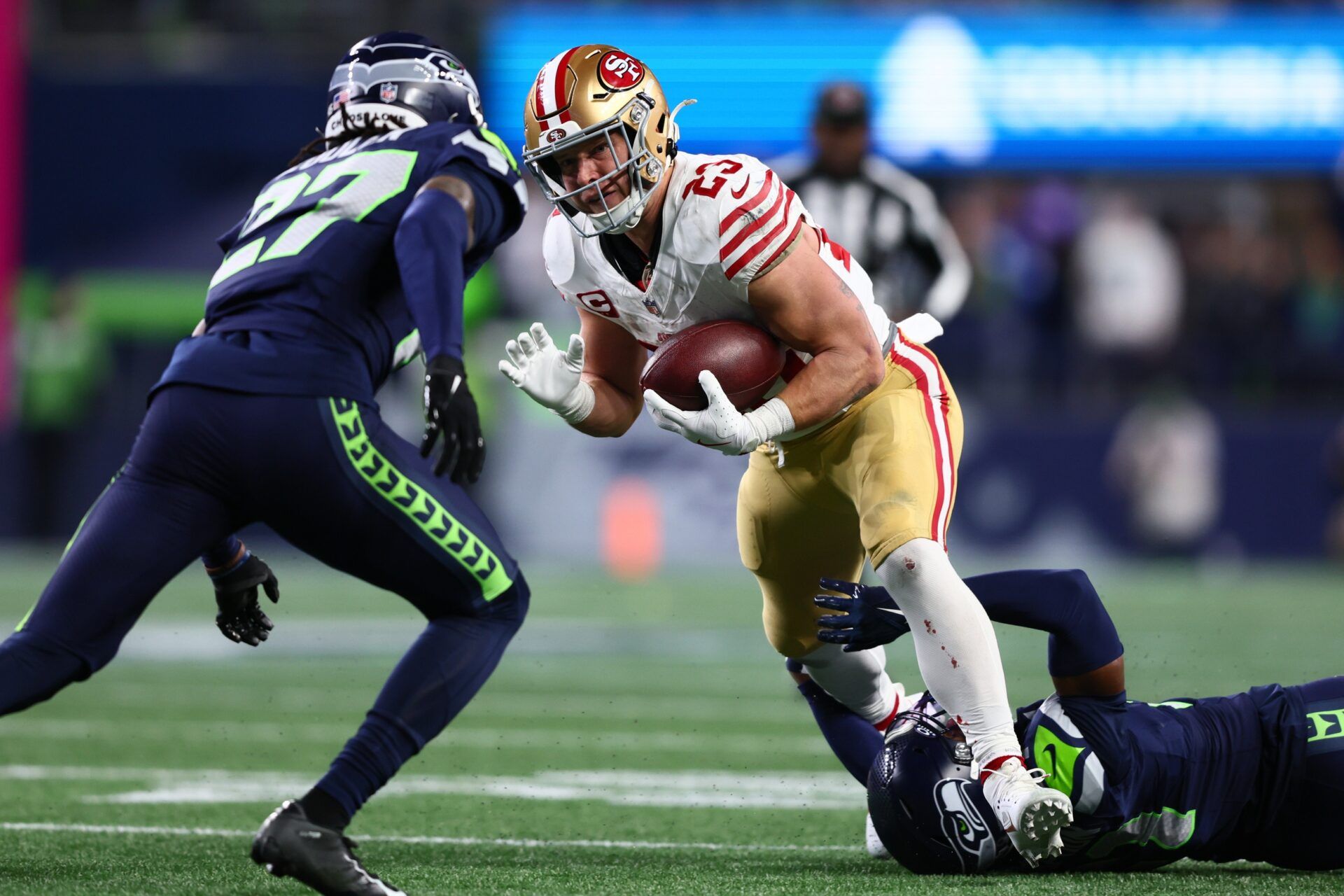San Francisco 49ers running back Christian McCaffrey (23) carries the ball as Seattle Seahawks cornerback Devon Witherspoon (21) defends during the first half in an NFC Divisional Round game at Lumen Field.