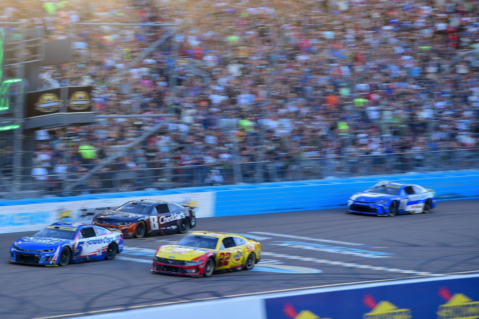 NASCAR Cup Series driver Kyle Larson (5) crosses the finish line ahead of driver Denny Hamlin (11) to win the title in the Cup Series Championship race at Phoenix Raceway.