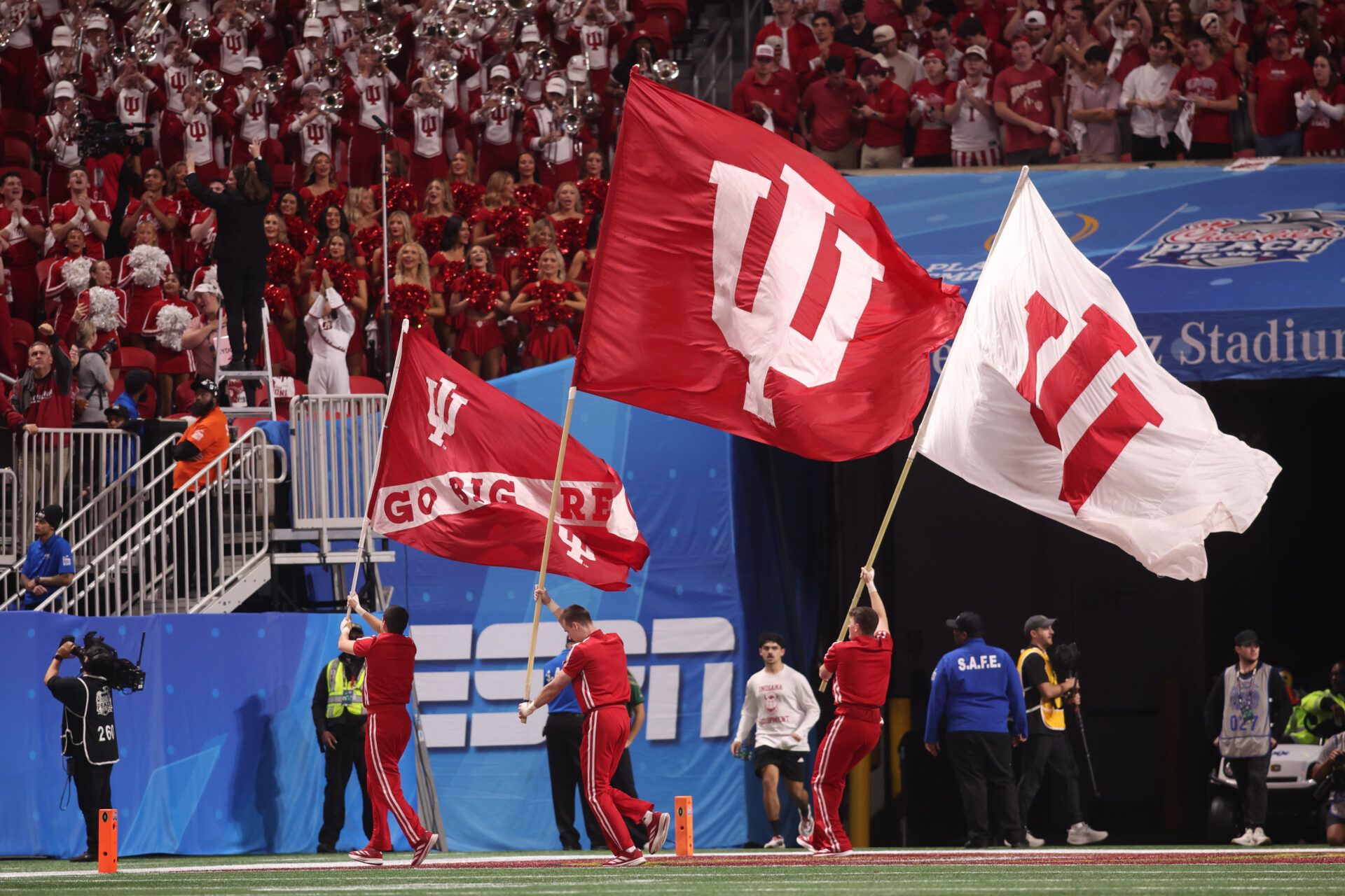 Indiana Hoosiers cheerleaders wave flags after a touchdown against the Oregon Ducks during the third quarter of the 2025 Peach Bowl and semifinal game of the College Football Playoff at Mercedes-Benz Stadium.