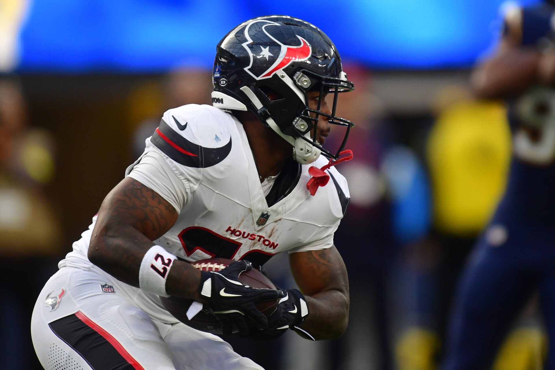 Houston Texans running back Woody Marks (27) carries the ball against the Los Angeles Chargers during the first half at SoFi Stadium.