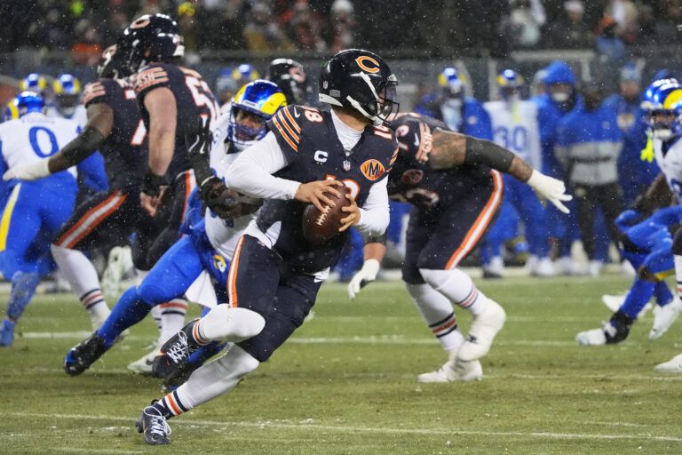 Chicago Bears quarterback Caleb Williams (18) scrambles against the Los Angeles Rams during the first quarter of an NFC Divisional Round game at Soldier Field.