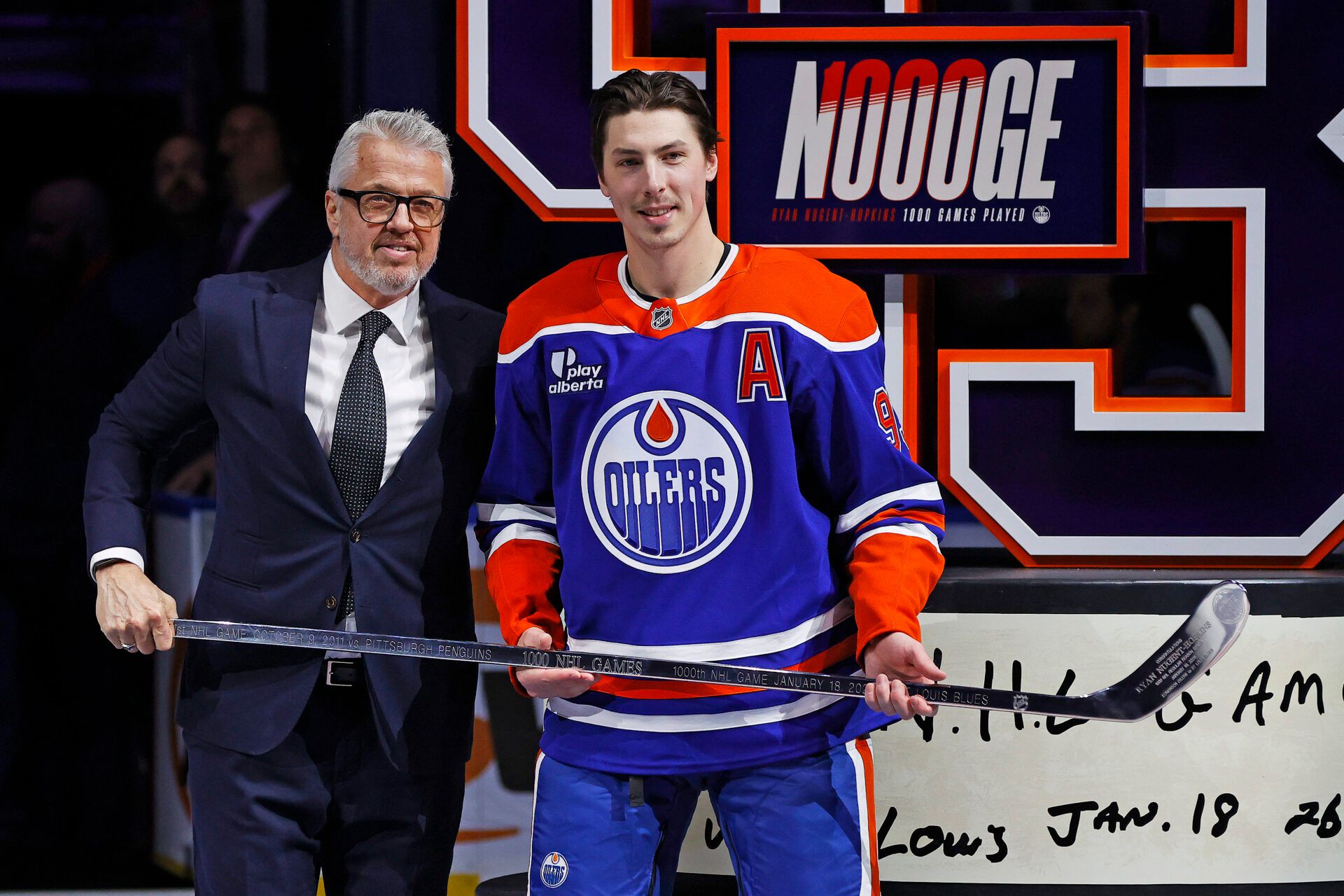 Edmonton Oilers president Jeff Jackson presents Ryan Nugent-Hopkins (93) with a sliver stick celebrating his 1000th game as an Edmonton Oiler at Rogers Place.