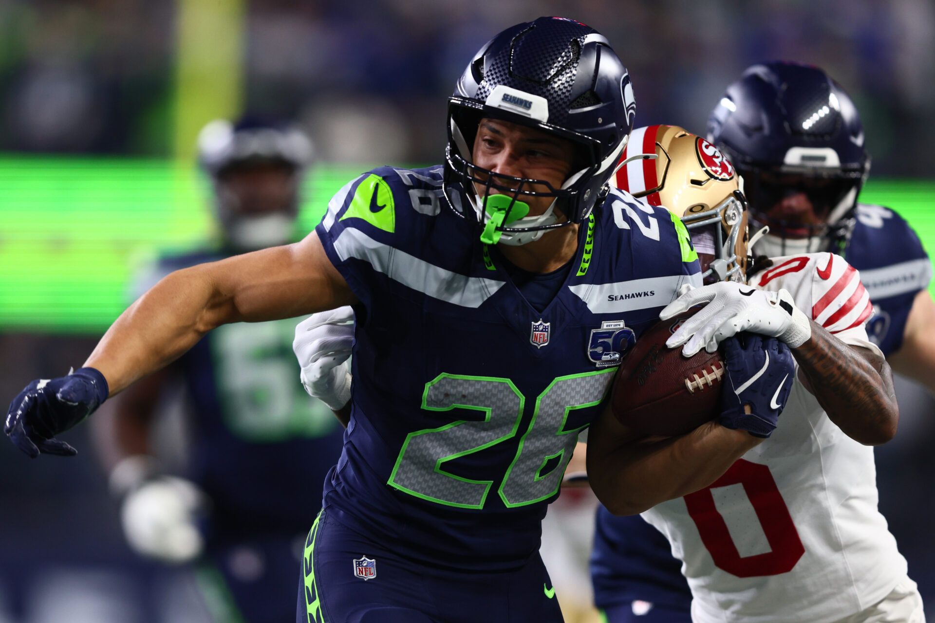Seattle Seahawks running back Zach Charbonnet (26) carries the ball as San Francisco 49ers cornerback Renardo Green (0) defends during the first half in an NFC Divisional Round game at Lumen Field.