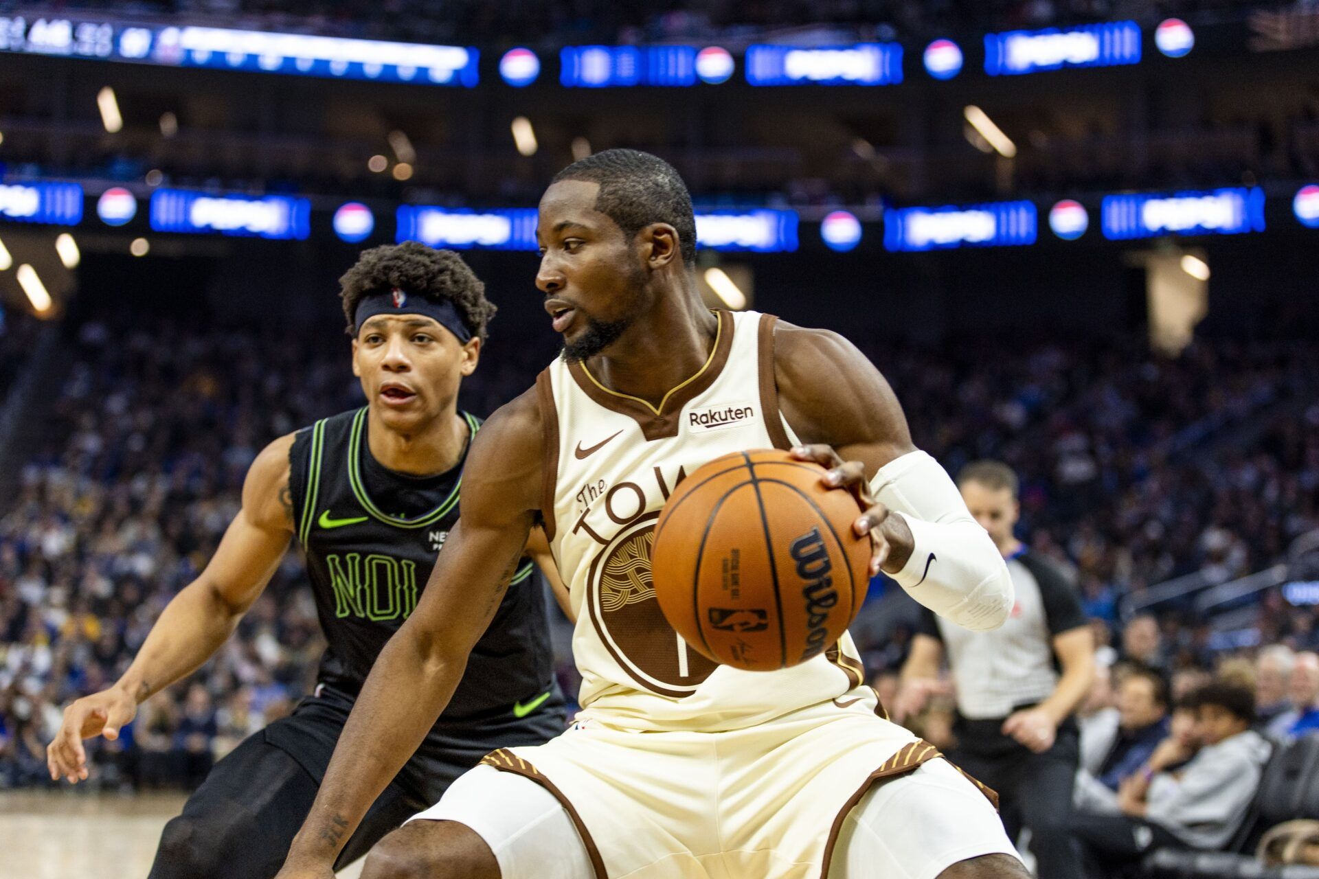 Golden State Warriors forward Jonathan Kuminga (1) controls the ball in front of New Orleans Pelicans guard Jeremiah Fears (0) during the third quarter at Chase Center.