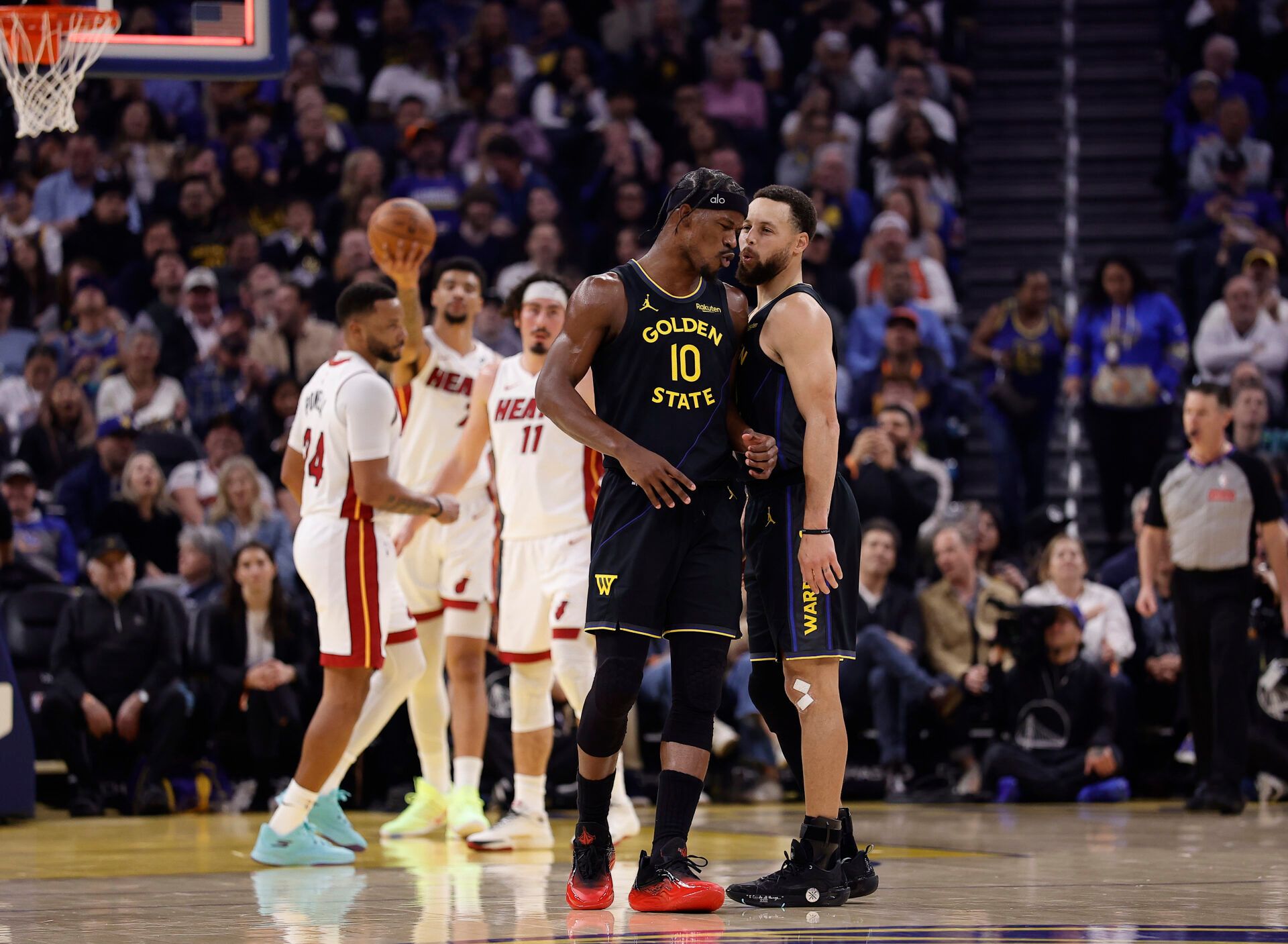 Golden State Warriors forward Jimmy Butler III (10) and guard Stephen Curry (30) react after Butler misses a shot at the buzzer during the first quarter against the Miami Heat at Chase Center.