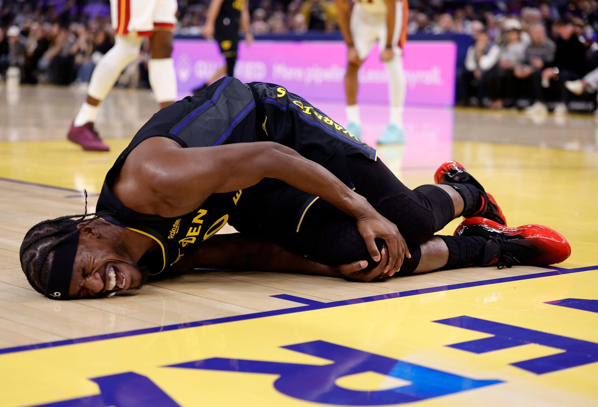 Golden State Warriors forward Jimmy Butler III (10) holds his right knee as he goes down with an injury during the third quarter against the Miami Heat at Chase Center.