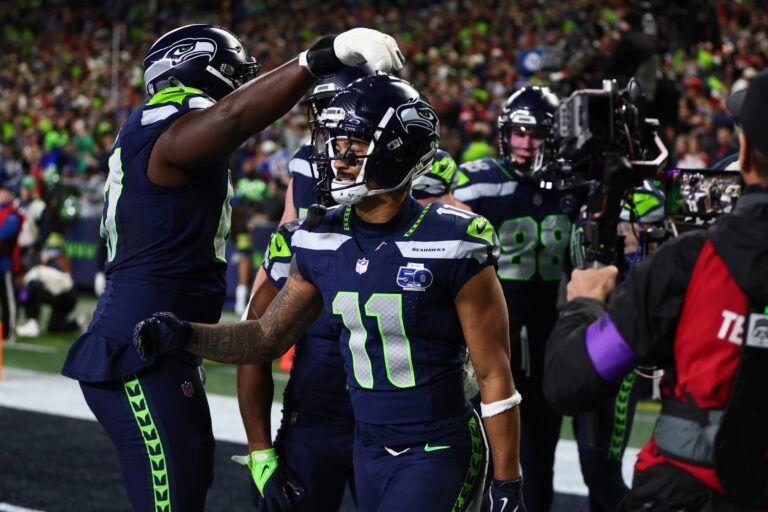 Seattle Seahawks wide receiver Jaxon Smith-Njigba (11) reacts with teammates after catching a touchdown pass against the San Francisco 49ers during the first half in an NFC Divisional Round game at Lumen Field.