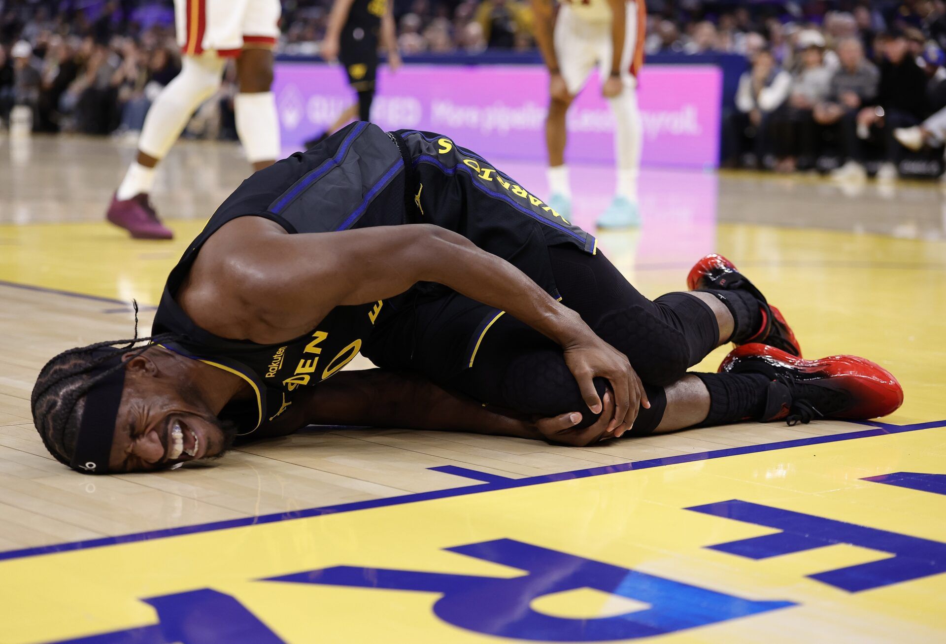 Golden State Warriors forward Jimmy Butler III (10) holds his right knee as he goes down with an injury during the third quarter against the Miami Heat at Chase Center.