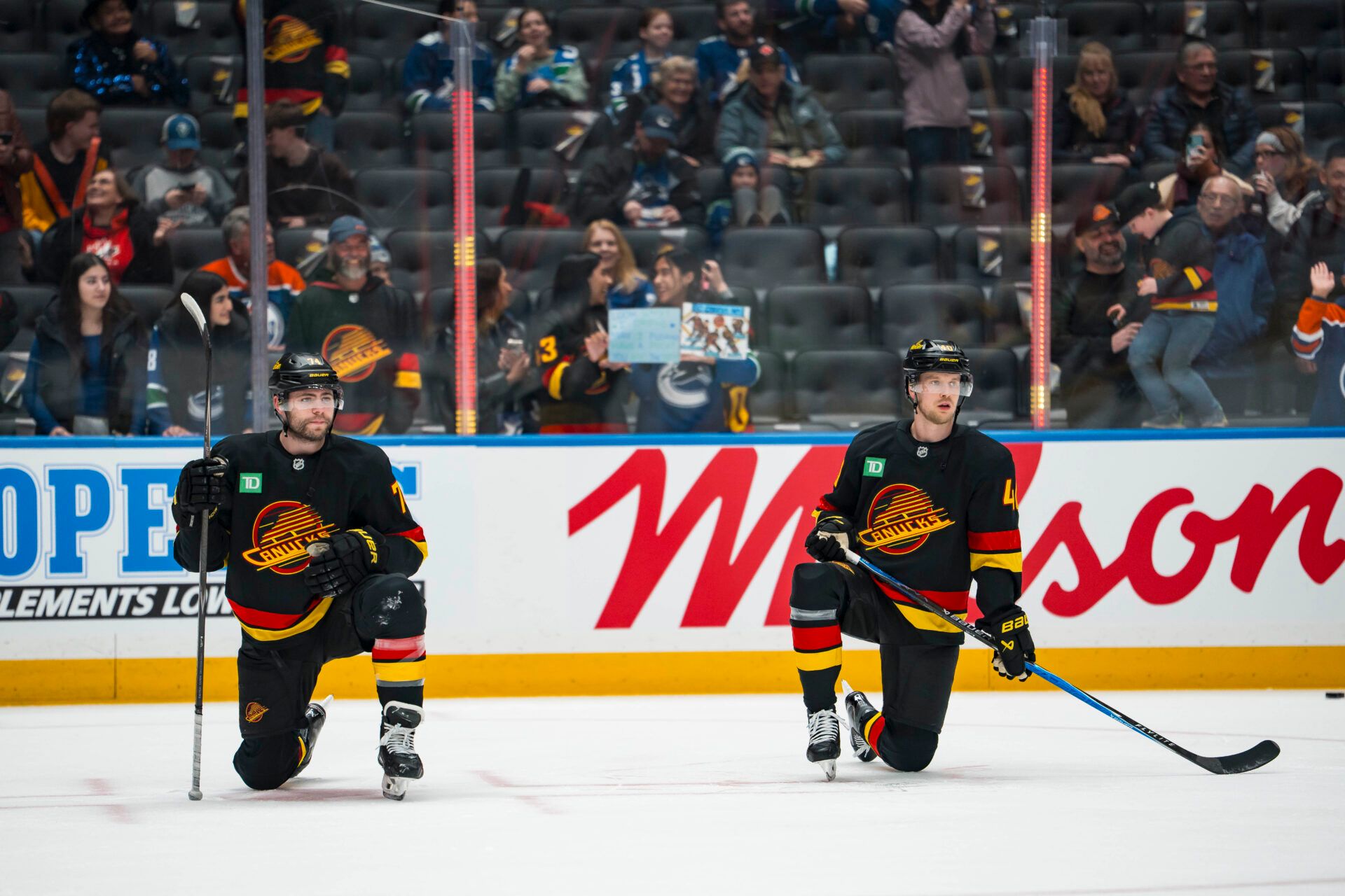 Vancouver Canucks forward Jake DeBrusk (74) and forward Elias Pettersson (40) rest during warm ups prior to a game against the Edmonton Oilers at Rogers Arena.