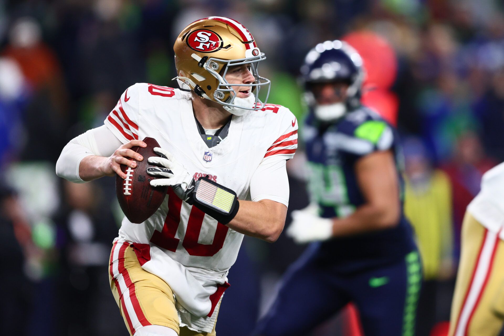 San Francisco 49ers quarterback Mac Jones (10) rolls out against the Seattle Seahawks during the second half in an NFC Divisional Round game at Lumen Field.