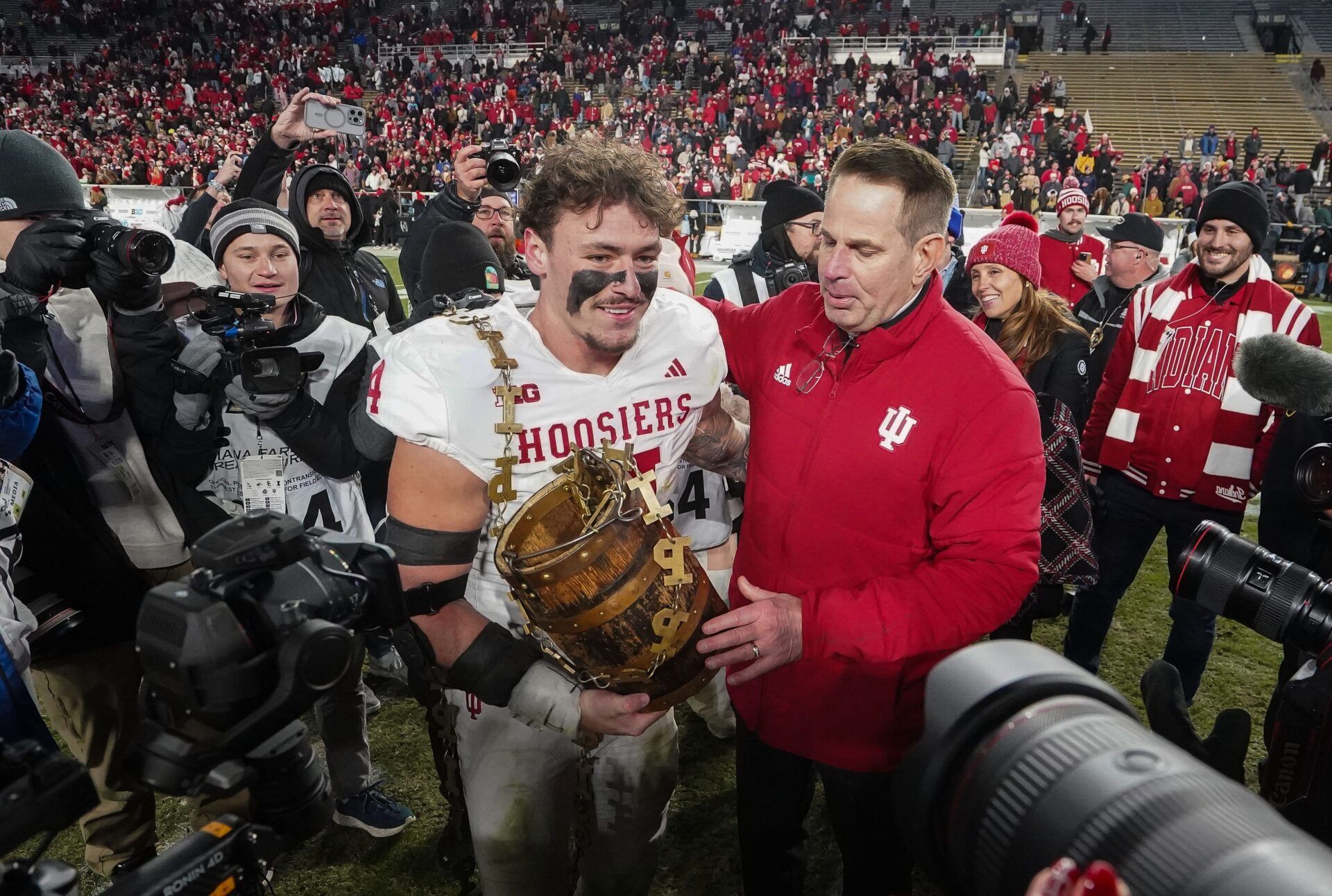 Indiana Hoosiers linebacker Aiden Fisher (4) holds the trophy with Indiana Hoosiers head coach Curt Cignetti Saturday, Nov. 29, 2025, during the 100th annual Old Oaken Bucket game at Ross-Ade Stadium in West Lafayette. Indiana Hoosiers defeated the Purdue Boilermakers, 56-3.