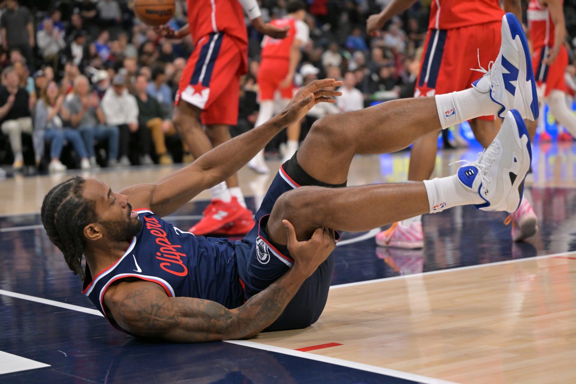 Los Angeles Clippers forward Kawhi Leonard (2) lands on the floor after a foul by Washington Wizards forward Justin Champagnie (9) in the first half at Intuit Dome.