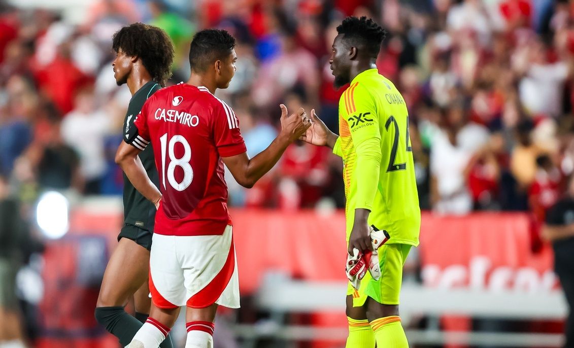 Manchester United midfielder Casemiro (18) shakes hands with teammate goalkeeper André Onana (24) following their match against Liverpool at Williams-Brice Stadium.