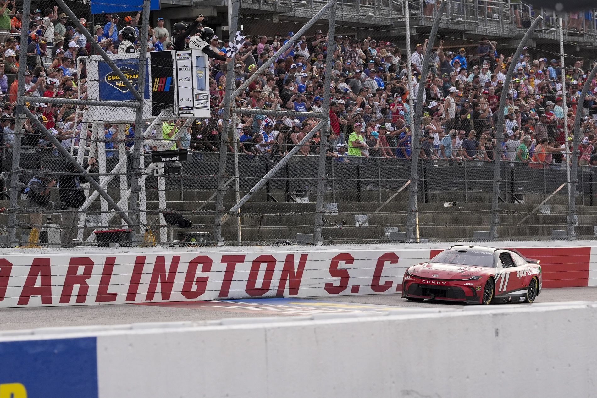 NASCAR Cup Series driver Denny Hamlin (11) takes the checkered flag for the win during the Goodyear 400 at Darlington Raceway.