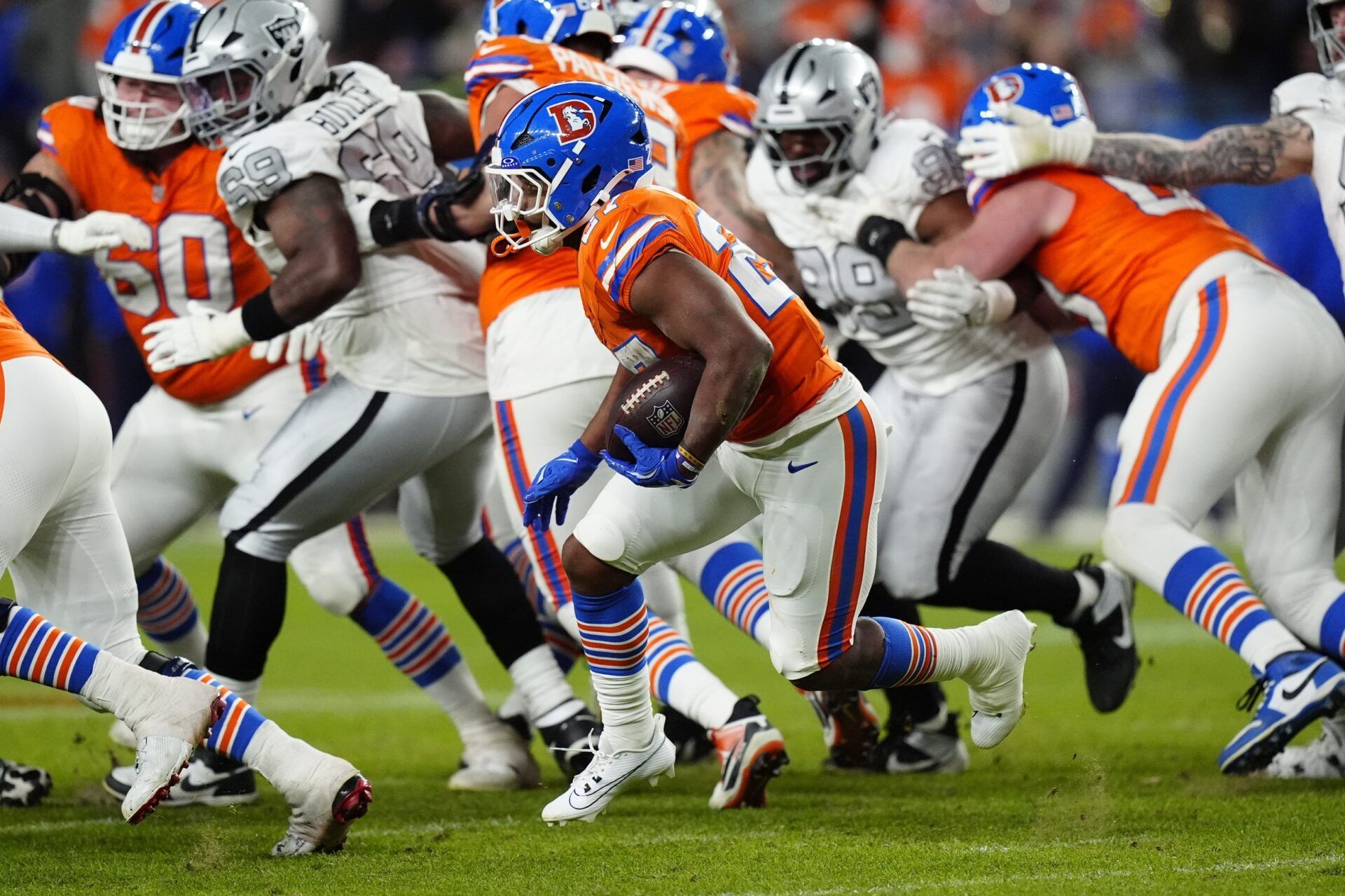 Denver Broncos running back J.K. Dobbins (27) rushes the ball against the Las Vegas Raiders during the second half at Empower Field at Mile High.
