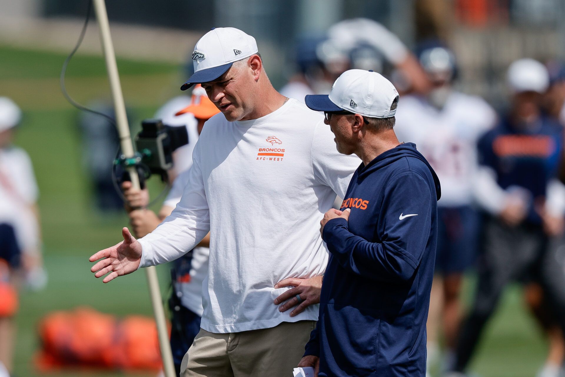 Denver Broncos offensive coordinator Joe Lombardi (L) and offensive assistant Pete Carmichael (R) during Denver Broncos Training Camp.