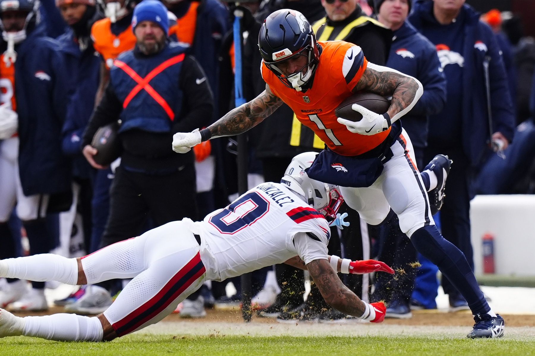 Denver Broncos tight end Evan Engram (1) makes a catch against New England Patriots cornerback Christian Gonzalez (0) during the first half in the 2026 AFC Championship Game at Empower Field at Mile High.